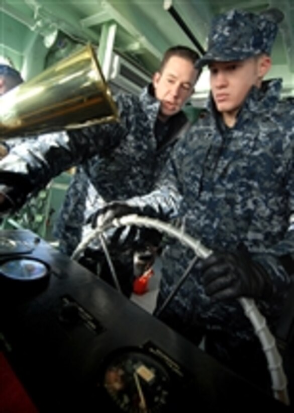 U.S. Navy Seaman Apprentice Jacob Horsch (right), assigned to Yard Patrol Operations at the U.S. Naval Academy, receives instruction from Petty Officer 2nd Class Christopher Abair while operating as the helmsman during a craft master qualification test in Annapolis, Md., on Jan. 13, 2011.  