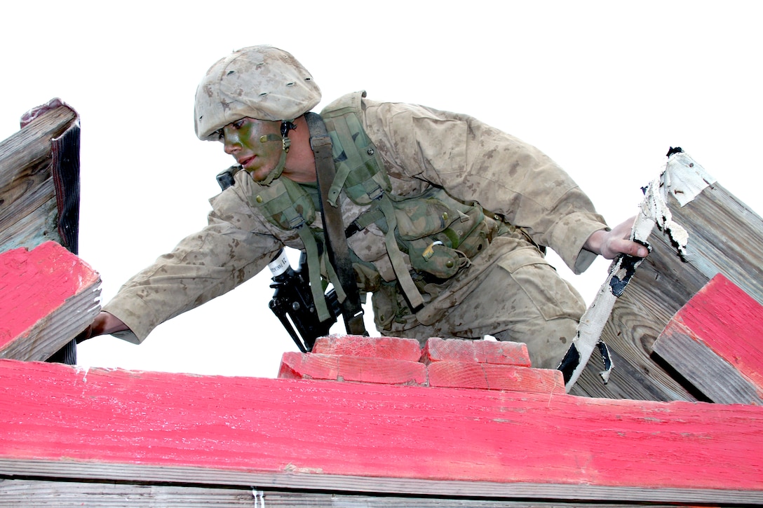 Private Marco N. Paniagua, Platoon 2114, Company E, 2nd Recruit Training Battalion, makes his way over the top of a simulated mine field obstacle during the 12-Stall portion of the Crucible, Jan. 19. Paniagua had to help his fellow Marines get an empty 5-gallon drum across this simulated mine field without touching any red paint or losing their gear.