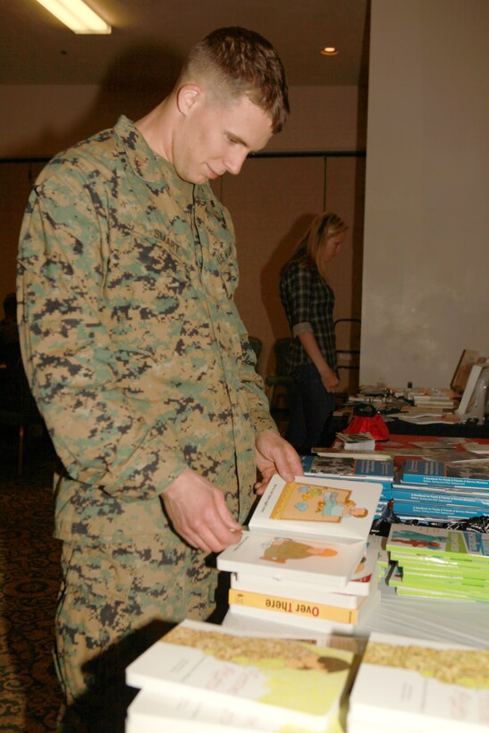 1st Lt. Nicholas Smart, 25, the 11th Marine Expeditionary Unit joint task force enabler officer-in-charge, browses through information provided by Military OneSource at a town hall meeting here Jan. 19. The meeting was held to educate service members with the unit and their families about resources available to them while their loved one is away.