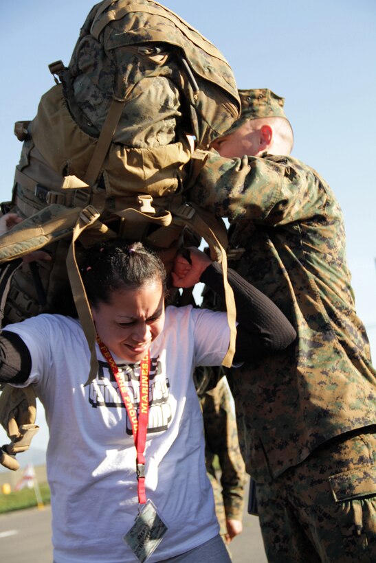 Sgt. Brett Logan helps Silvia Rosales, 28, from White Bear Lake, Minn., strap on a Marine Corps pack Jan. 20 to see how much weight recruits must carry on boot camp hikes during the 2011 Recruiting Station Twin Cities Educators' Workshop. Rosales is the Hudson High School Career Center Coordinator. Thirty-seven educators from Minnesota and North Dakota attended the workshop. For more photos of the event, visit the RS Twin Cities fan page at www.facebook.com/rstwincities.