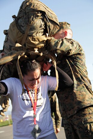 Sgt. Brett Logan helps Silvia Rosales, 28, from White Bear Lake, Minn., strap on a Marine Corps pack Jan. 20 to see how much weight recruits must carry on boot camp hikes during the 2011 Recruiting Station Twin Cities Educators' Workshop. Rosales is the Hudson High School Career Center Coordinator. Thirty-seven educators from Minnesota and North Dakota attended the workshop. For more photos of the event, visit the RS Twin Cities fan page at www.facebook.com/rstwincities.