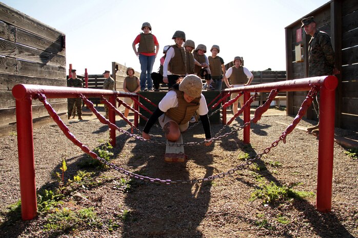 Silvia Rosales, 28, from White Bear Lake, Minn., makes her way toward the end of an obstacle Jan. 20 during the 2011 Recruiting Station Twin Cities Educators' Workshop. The obstacle was one of several stations recruits must complete during the Crucible, a 54-hour training event conducted near the end of boot camp. Rosales is the Hudson High School Career Center Coordinator. Thirty-seven educators from Minnesota and North Dakota attended the workshop. For more photos of the event, visit the RS Twin Cities fan page at www.facebook.com/rstwincities.