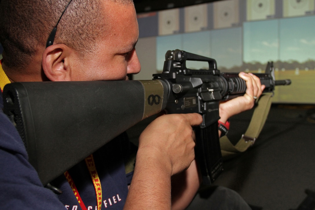 James Strait, 40, from San Antonio, Texas, tests his sharpshooter skills on an indoor simulated marksmanship trainer Jan. 20 during the 2011 Recruiting Station Twin Cities Educators' Workshop. Strait is the Minnesota Transitions School's Banaadir Academy principal. Thirty-seven educators from Minnesota and North Dakota attended the workshop. For more photos of the event, visit the RS Twin Cities fan page at www.facebook.com/rstwincities.