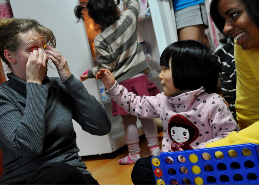 Chief Master Sgt. Carrie Kruse, 51st Logistics Readiness Squadron, Osan Air Base, places chips on her eyes while playing with children at the Cheonan orphanage during a visit by Osan Airmen, Jan. 15. The Osan base chapel organizes a monthly trip to local orphanages, where volunteers have the opportunity to play with and talk to the children. (U.S. Air Force photo by Senior Airman Evelyn Chavez)