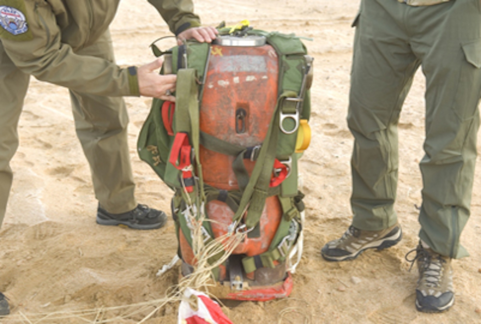 Members of the 418th Flight Test Squadron perform functional testing on the ground for the experimental parachute system called the Guardian Angel Advance Parachute System. GAAPS is a threefold parachute system, which includes a freefall parachute system, a static-line parachute and a tandem parachute system. The parachute's canopy is made with a special type of fabric designed to allow the user to land at high altitudes. (U.S. Air Force photo/Rob Densmore) 