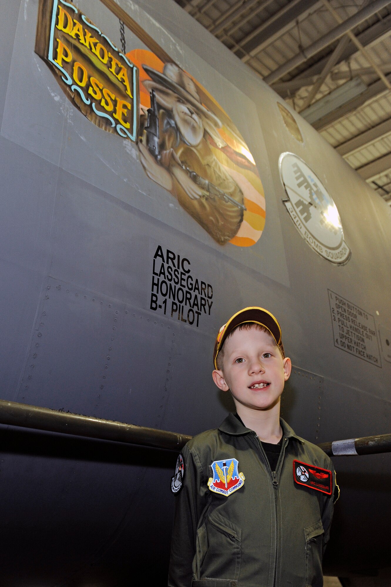 Aric Lassegard stands in front of a B-1B Lancer with his name painted on the nose at Ellsworth Air Force Base, S.D., Jan. 13, 2011.  Aric was treated as an honorary member of the 34th BS as part of the Aircrew for a Day program. (U.S. Air Force photo/Staff Sgt. Marc I. Lane)