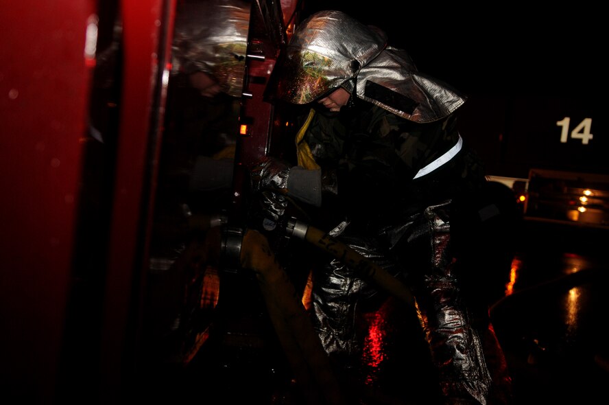 A fireman from the 18th Civil Engineer Squadron turns on the water pump on a fire truck in order to extinguish a simulated burning building during Beverly High 11-02, a local operational readiness exercise at Kadena Air Base, Japan, Jan 20.  Kadena's emergency response units use exercises to prepare for real-world emergencies. (U.S. Air Force photo/Airman 1st Class Jarvie Z. Wallace)