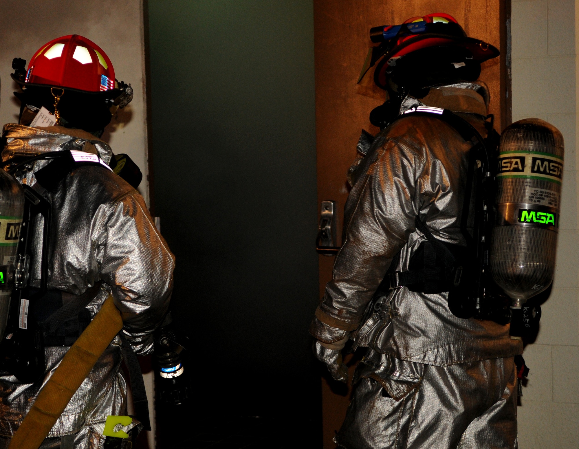 Firemen from Kadena's 18th Civil Engineer Squadron prepare to enter a simulated burning building during Beverly High 11-02, a local operational readiness exercise at Kadena Air Base, Japan, Jan. 20. During the exercise, the firefighters extracted simulated injured victims and honed their emergency response skills. (U.S. Air Force photo/Airman 1st Class Jarvie Z. Wallace)