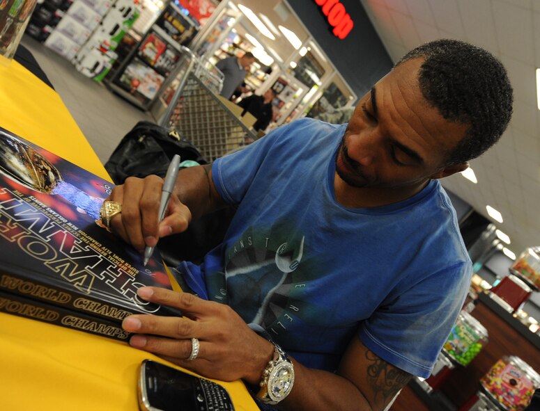 Michael K. Lewis, former New Orleans Saints wide receiver, autographs a book for a fan on Jan. 19 at the Barksdale Base Exchange. Although he no longer plays for the Saints, Mr. Lewis was awarded a Super Bowl ring after the Saints won in recognition of his continuing role as the team ambassador. (U.S. Air Force photo/Senior Airman Alexandra M. Boutte) (RELEASED)
