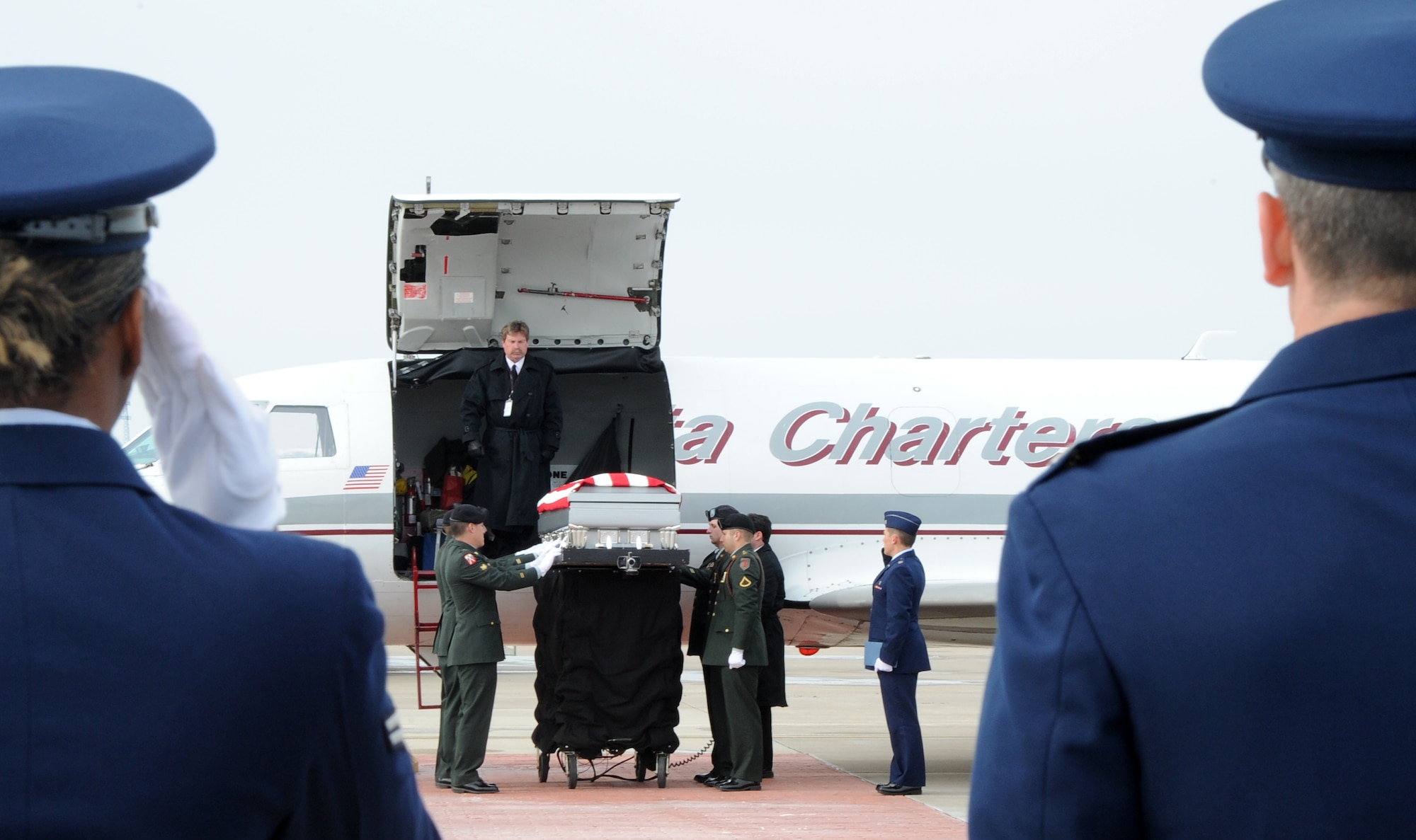 McConnell Airmen salute as U.S. Army Staff Sgt. Eric Nettleton’s casket is lowered Jan. 14, 2011, McConnell Air Force Base, Kan. Staff Sgt. Nettleton’s remains were escorted off-base by the Kansas Patriot Guard and his family to include his brother, Senior Airman Clayton Nettleton, 22nd Logistics Readiness Squadron storage and issue technician. (U.S. Air Force Photo/Airman 1st Class Katrina M. Brisbin)