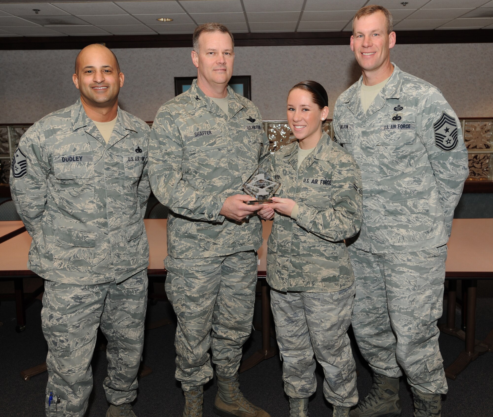 Col. Don Shaffer, 319th Air Refueling Wing Commander, presents Airman 1st Class Courtney Moya, 319th Air Refueling Wing, with a Diamond Sharp Award Jan. 20 at Airey Dining Facility here, accompanied by Command Chief Master Sgt. David Carlson, 319th Air Refueling Wing, and Master Sgt. Luca Dudley, 319th Comptroller Squadron first sergeant. The Diamond Sharp Award is given to those Airmen who epitomize service before self and strive for excellence at work and off duty. (U.S. Air Force photo by Staff Sgt. Suellyn Nuckolls)