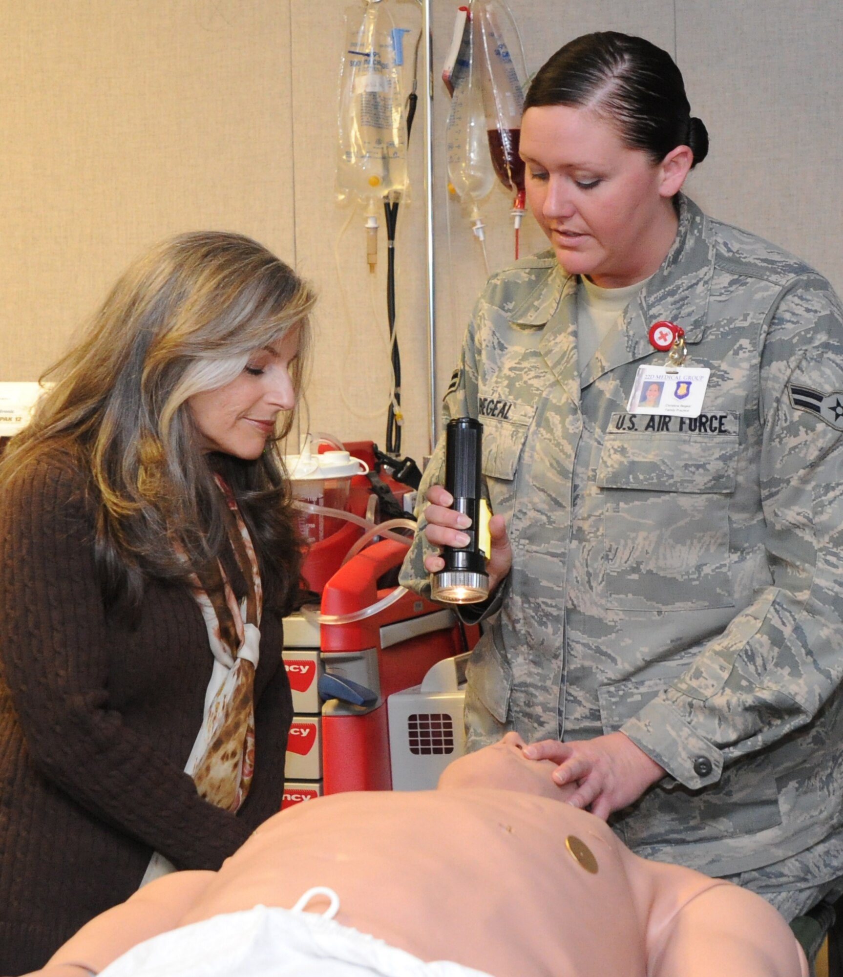 Diana Johns, wife of Gen. Raymond E. Johns Jr., Air Mobility Command commander, observes Airman 1st Class Christina Begeal, 22nd Medical Operations Squadron medical technician, as she dilates a Meti-man’s eyes Jan. 13, 2011, McConnell Air Force Base, Kan. Mrs.  Johns visited the clinic as part of her tour through different base organizations. The $85,000 Meti-man, a human patient simulator, trains Airmen in critical thinking skills needed to manage actual trauma patients more effectively. (U.S. Air Force Photo/Airman 1st Class Katrina M. Brisbin)