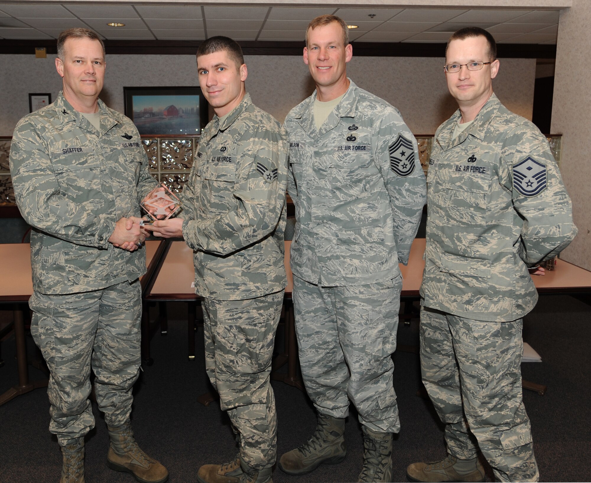 Col. Don Shaffer, 319th Air Refueling Wing Commander, presents Senior Airman Christopher Marmet, 319th Operations Support Squadron, with a Diamond Sharp Award Jan. 20 at Airey Dining Facility here, accompanied by Command Chief Master Sgt. David Carlson, 319th Air Refueling Wing, and Master Sgt. Patrick Michaels, 319th Operations Support Squadron first sergeant. The Diamond Sharp Award is given to those Airmen who epitomize service before self and strive for excellence at work and off duty. (U.S. Air Force photo by Staff Sgt. Suellyn Nuckolls)