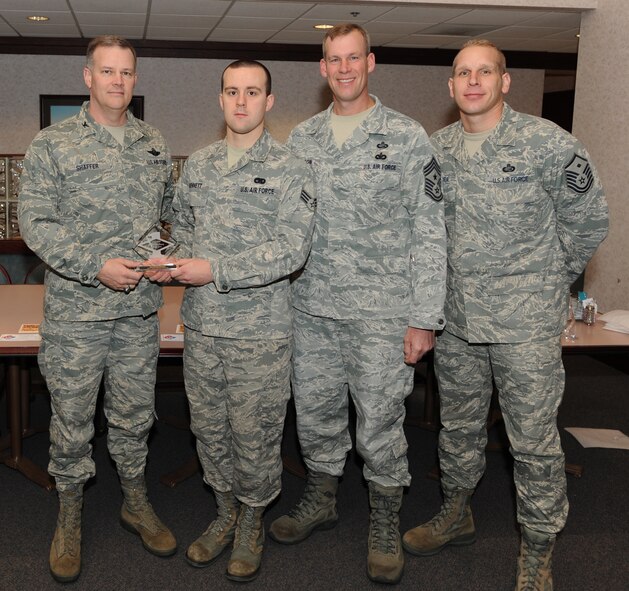 Col. Don Shaffer, 319th Air Refueling Wing Commander, presents Senior Airman Patrick Bennett, 319th Logistics Readiness Squadron, with a Diamond Sharp Award Jan. 20 at Airey Dining Facility here, accompanied by Command Chief Master Sgt. David Carlson, 319th Air Refueling Wing, and Master Sgt. Aaron Mulder, 319th Logistics Readiness Squadron first sergeant. The Diamond Sharp Award is given to those Airmen who epitomize service before self and strive for excellence at work and off duty. (U.S. Air Force photo by Staff Sgt. Suellyn Nuckolls)