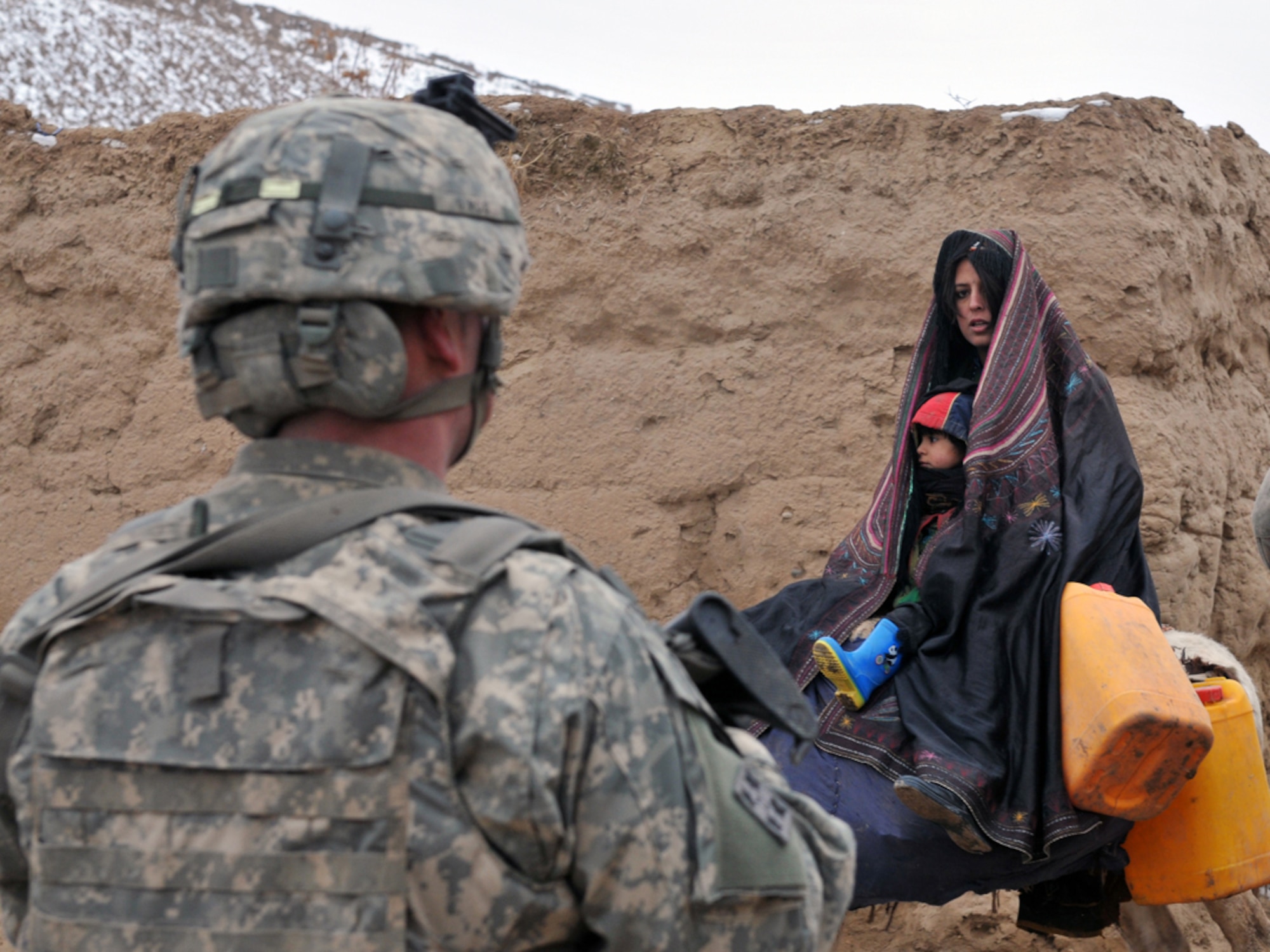 BADGHIS, Afghanistan -- An Afghan woman and her son ride a donkey through a U.S. Army scout presence patrol in Nawbor Village, Bala Murghab District, Badghis Province, Afghanistan, Jan. 16, 2011.  The scouts, who hail from White Platoon, Bulldog Troop, 7th Squadron, 10th Cavalry Regiment, 1st Brigade, 4th Infantry Division, at Fort Carson, Colo., identified the woman's family as having recently moved to the village, after insurgents ran them out of their house  - which was outside Bala Murghab's security bubble. (U.S. Air Force photo/Tech. Sgt. Kevin Wallace)