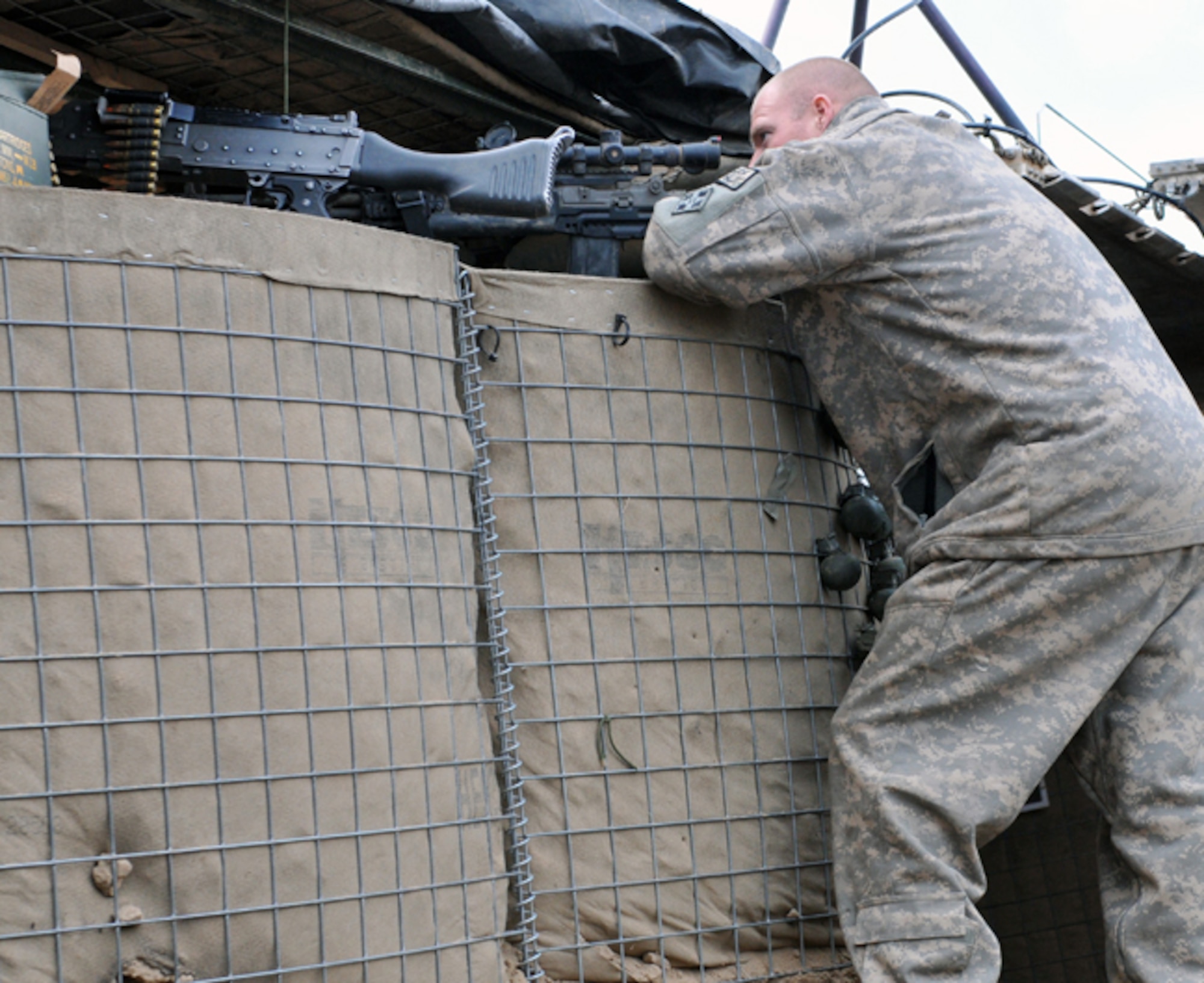 BADGHIS, Afghanistan -- Army Staff Sgt. Jason Kennedy, a scout with the 7th Squadron, 10th Cavalry Regiment, 1st Brigade, 4th Infantry Division, at Fort Carson, Colo., observes a village below Observation Post Cougar, Badghis Province, Afghanistan, Jan. 18, 2011. Sergeant Kennedy hails from Watervliet, Mich. (U.S. Air Force photo/Tech. Sgt. Kevin Wallace)