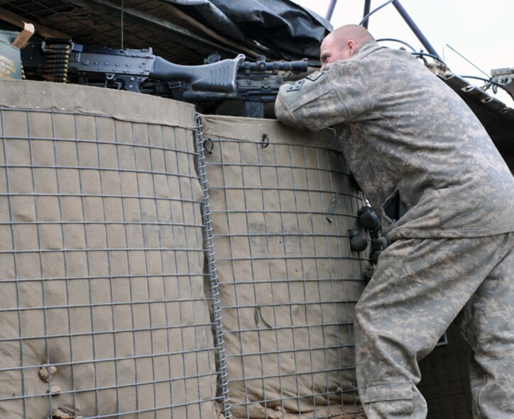 BADGHIS, Afghanistan -- Army Staff Sgt. Jason Kennedy, a scout with the 7th Squadron, 10th Cavalry Regiment, 1st Brigade, 4th Infantry Division, at Fort Carson, Colo., observes a village below Observation Post Cougar, Badghis Province, Afghanistan, Jan. 18, 2011. Sergeant Kennedy hails from Watervliet, Mich. (U.S. Air Force photo/Tech. Sgt. Kevin Wallace)