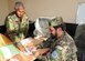 KABUL, Afghanistan - Lt. Col. Sheenwarai Matiuallah, the Chief of Staff of Pohantoon-e-Hawayee, the Afghan Air Force's "Big Air School" signs a document for a subordinate, in Kabul, Afghanistan.(U.S. Navy photo by Mass Communications Specialist 3rd Class Petty Officer Jared E. Walker/ RELEASED).