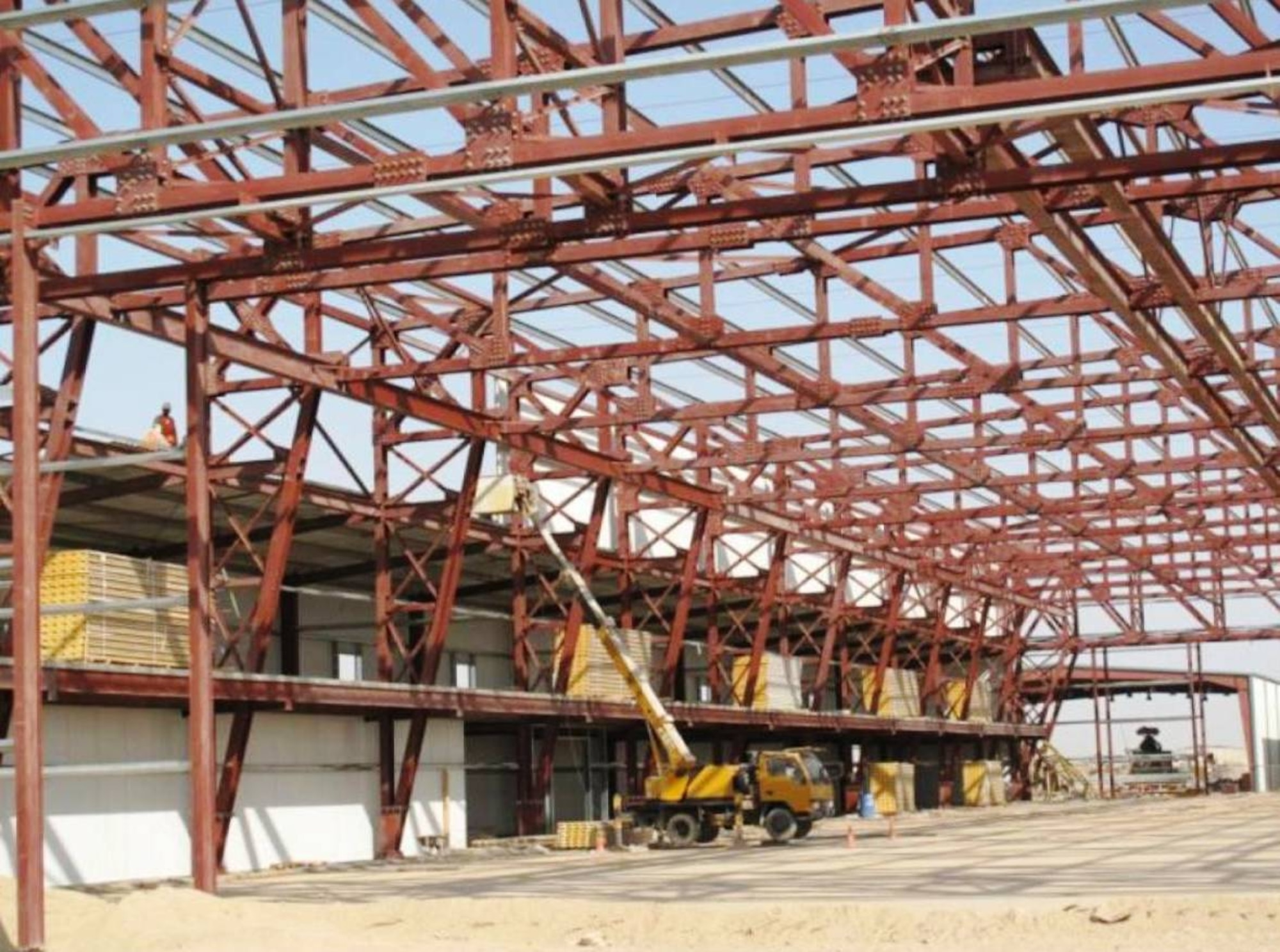 An Iraqi construction crew unloads pallets of equipment for the aircraft maintenance hangar in Taji.  The massive aircraft hangar is a $9.8 million project that began in 2009. (Courtesy photo)