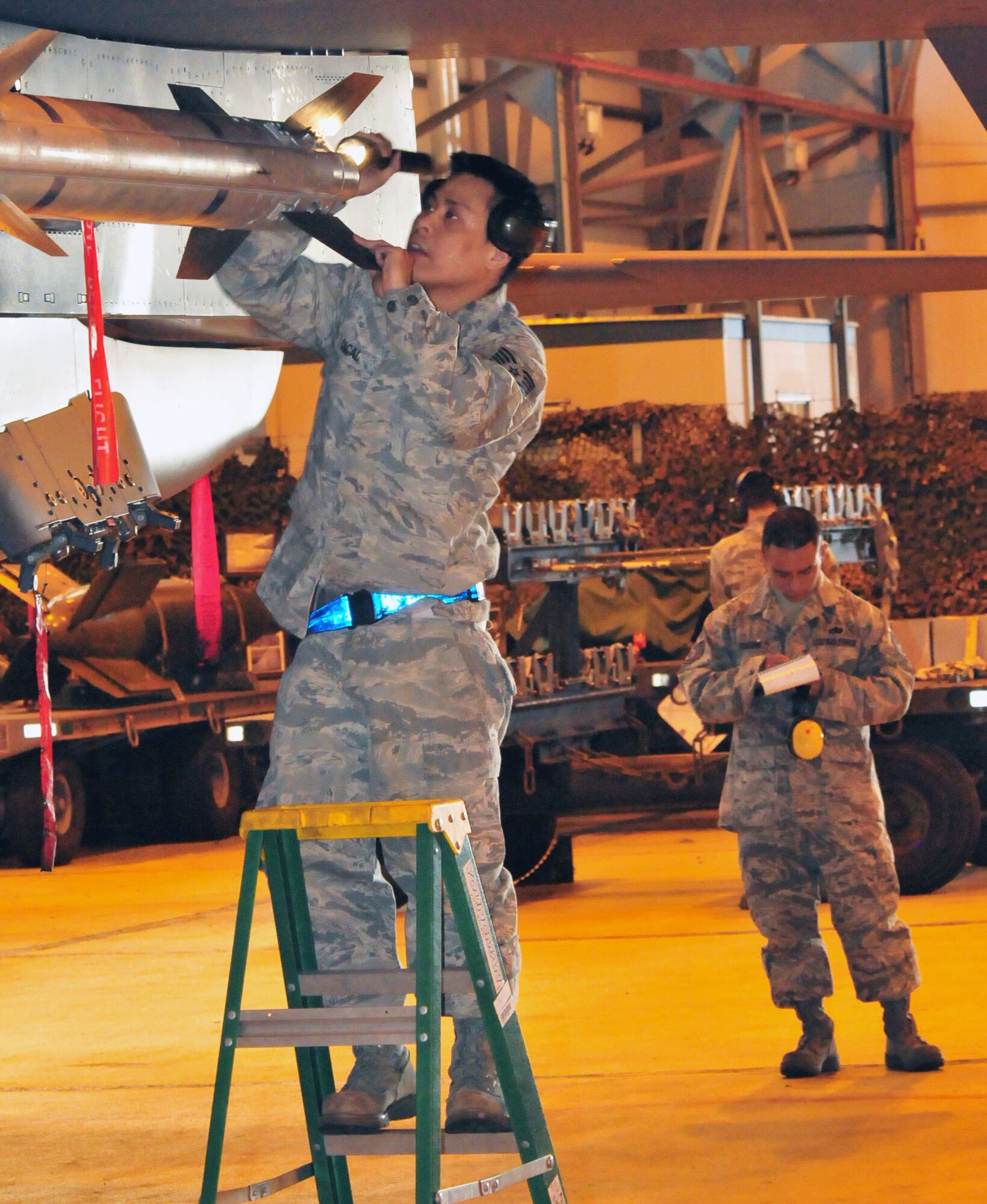 ROYAL AIR FORCE LAKENHEATH, England -- Tech. Sgt. Ryan Cacal, 48th Aircraft Maintenance Squadron, inspects an AIM-9M Sidewinder missile as an observer grades his performance during the Annual Load Crew Competition of the Year, Jan.18. During the completion, each team is judged on their uniform and military bearing, a written test, and a toolbox inspection before competing in a timed hands-on assessment of loading munitions onto an F-15E. (U.S. Air Force Photo/ Staff Sgt. Megan P. Lyon)