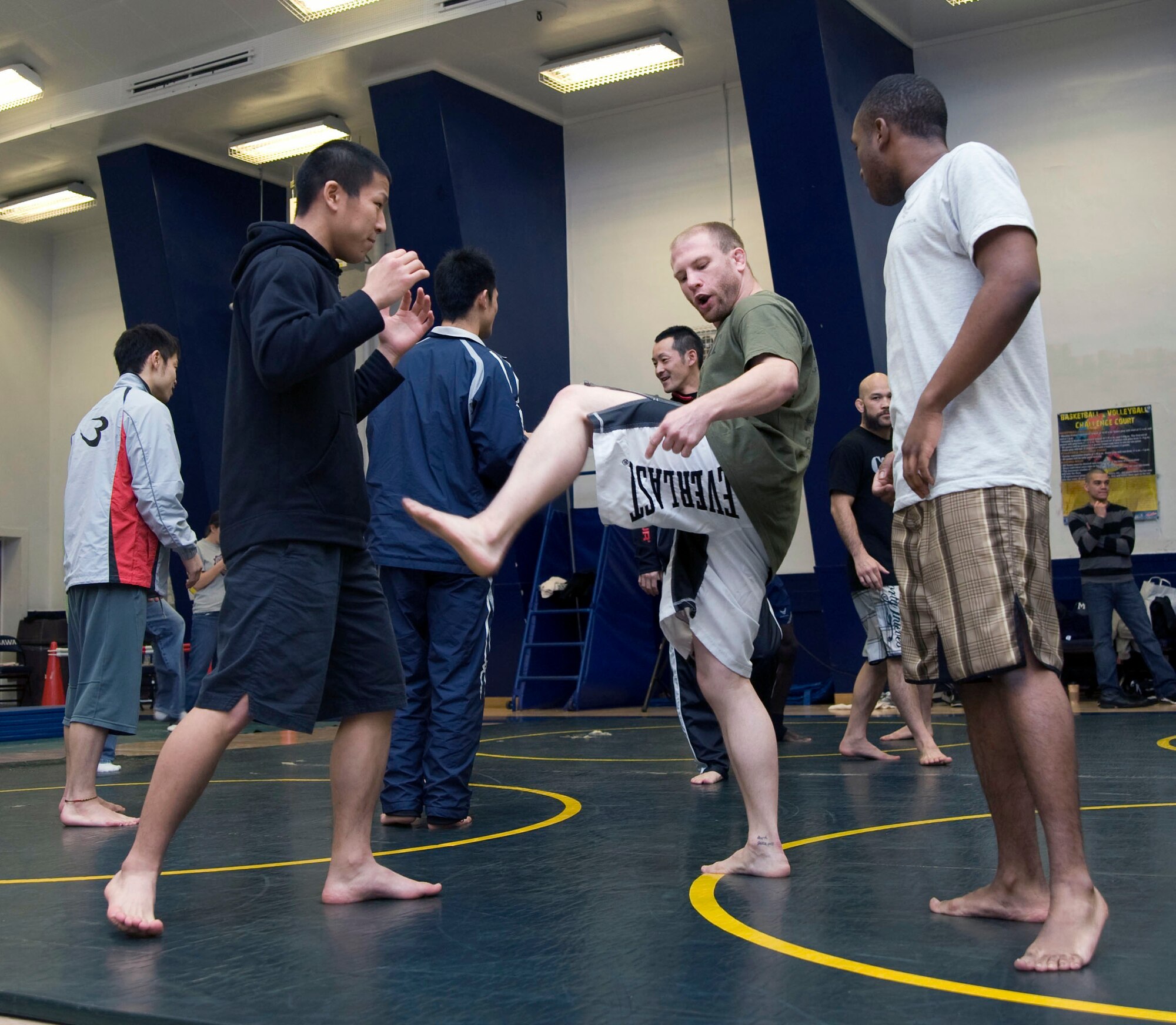 Mixed Martial Arts member Nate "Rock" Quarry from  Gresham, Oregon, demonstrates a kick to U.S. Air Force Airman First Class Valentino Harris, 35th Logistics Readiness Squadron and Takahito Itoh, Japan Air Self- Defense Force member at Misawa Air Base, Japan, Jan. 15, 2011. Quarry made his professional mixed martial arts debut in 2001. (U.S. Air Force photo by Tech. Sgt. Russell McBride/Released)