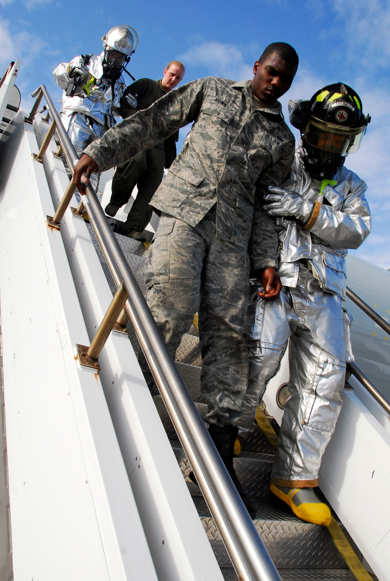Firemen from Kadena's 18th Civil Engineer Squadron escort "victims" from a simulated burning aircraft during Beverly High 11-02, a local operational readiness exercise on Kadena Air Base, Japan, Jan. 19. Kadena's emergency response units worked together to test their capabilities for potential real-world emergencies. (U.S. Air Force photo/ Airman 1st Class Maeson L. Elleman)