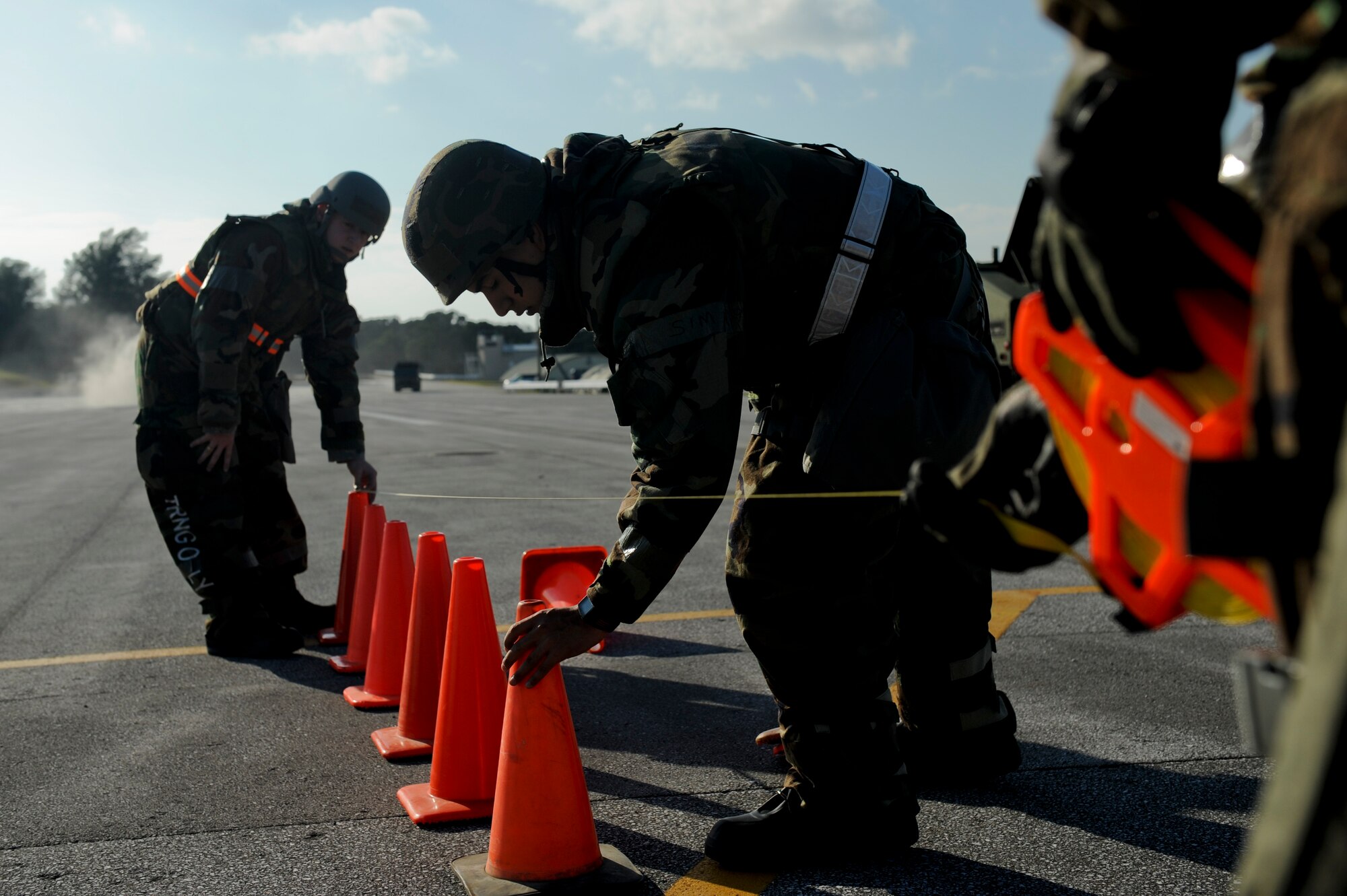 (From left to right) Senior Airman Mark Scott, Airman 1st Class Jose Aceves and Senior Airman Brandon Townes, all members from the 718th Civil Engineer Squadron, align the landing path of the runway during Beverly High 11-02, a local operational readiness exercise, at Kadena Air Base, Jan. 19. The 18th Civil Engineer Group is tasked with establishing the running runway after an attack. Kadena’s Airmen use LOREs to test themseves in the ability to survive and operate (ATSO) under various conditions.  (U.S. Air Force photo/ Staff Sgt. Jonathan Steffen) 