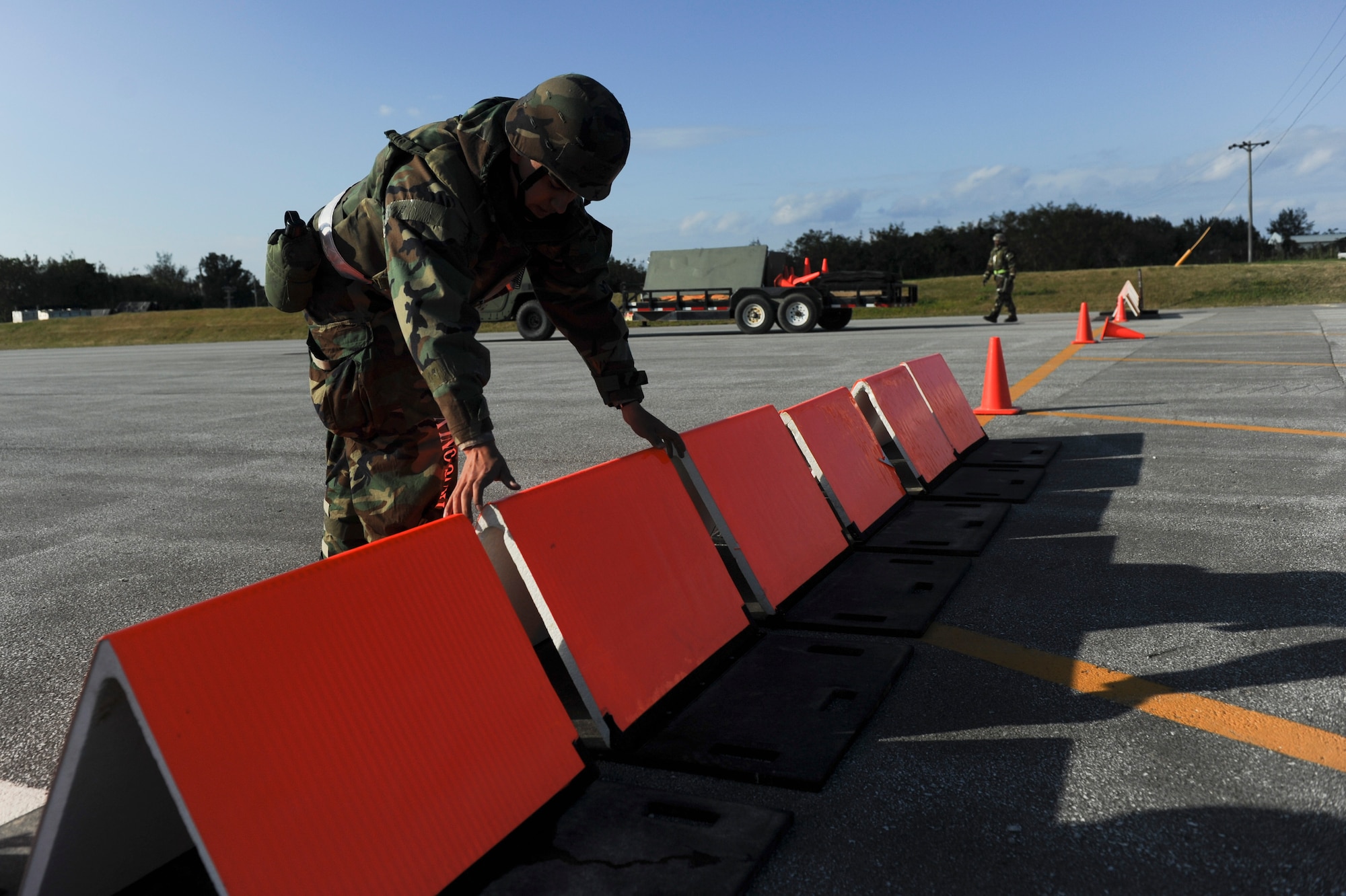 Airman 1st Class Jose Aceves, a member of the 718th Civil Engineer Squadron, marks the threshold of the runway during Beverly High 11-02, a local operational readiness exercise at Kadena Air Base, Japan, Jan. 19. The 18th Civil Engineer Group is responsible for establishing an operational runway after an attack. (U.S. Air Force photo/ Staff Sgt. Jonathan Steffen)