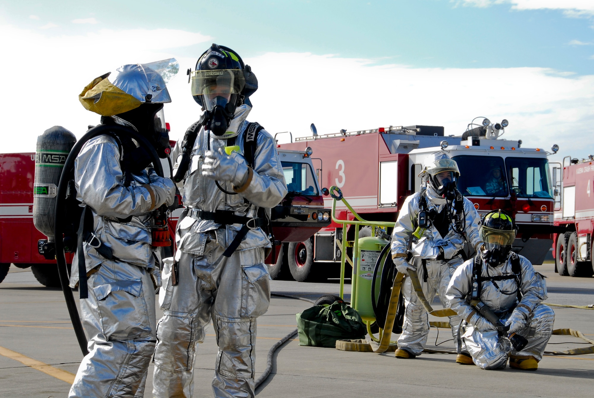 Firemen from Kadena's 18th Civil Engineer Squadron coordinate their aircraft entry strategy while others stand prepared with a fire hose for a simulated burning aircraft exercise during Beverly High 11-02, a local operational readiness exercise on Kadena Air Base, Japan, Jan. 19. Kadena's emergency response units use exercises to not only prepare for operational readiness inspections, but for potentially real-world emergencies. (U.S. Air Force photo/ Airman 1st Class Maeson L. Elleman)