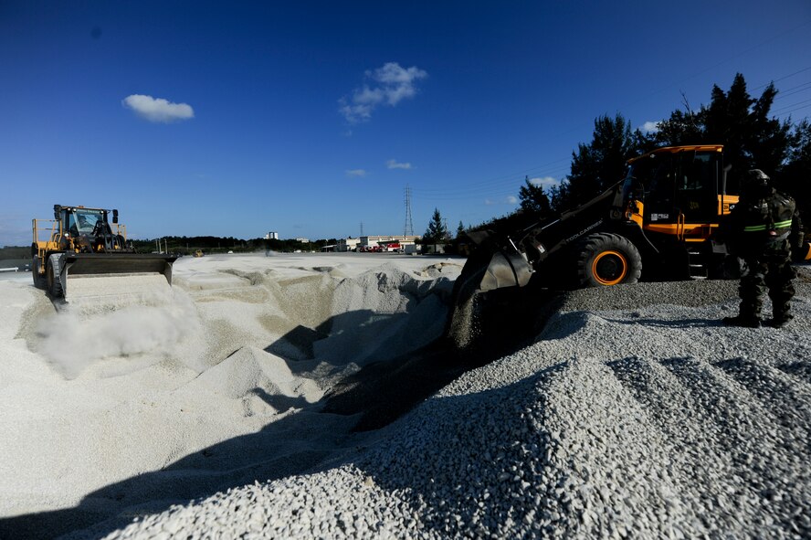 Airmen from the 18th Civil Engineer Squadron push gravel with bobcats into a crater from a simulated bomb drop during Beverly High 11-02, a local operational readiness exercise at Kadena Air Base, Japan, Jan. 19. This scenario tested the 18th Civil Engineer Group’s ability to establish an operational runway after an attack on the base. (U.S. Air Force photo/ Staff Sgt. Jonathan Steffen)