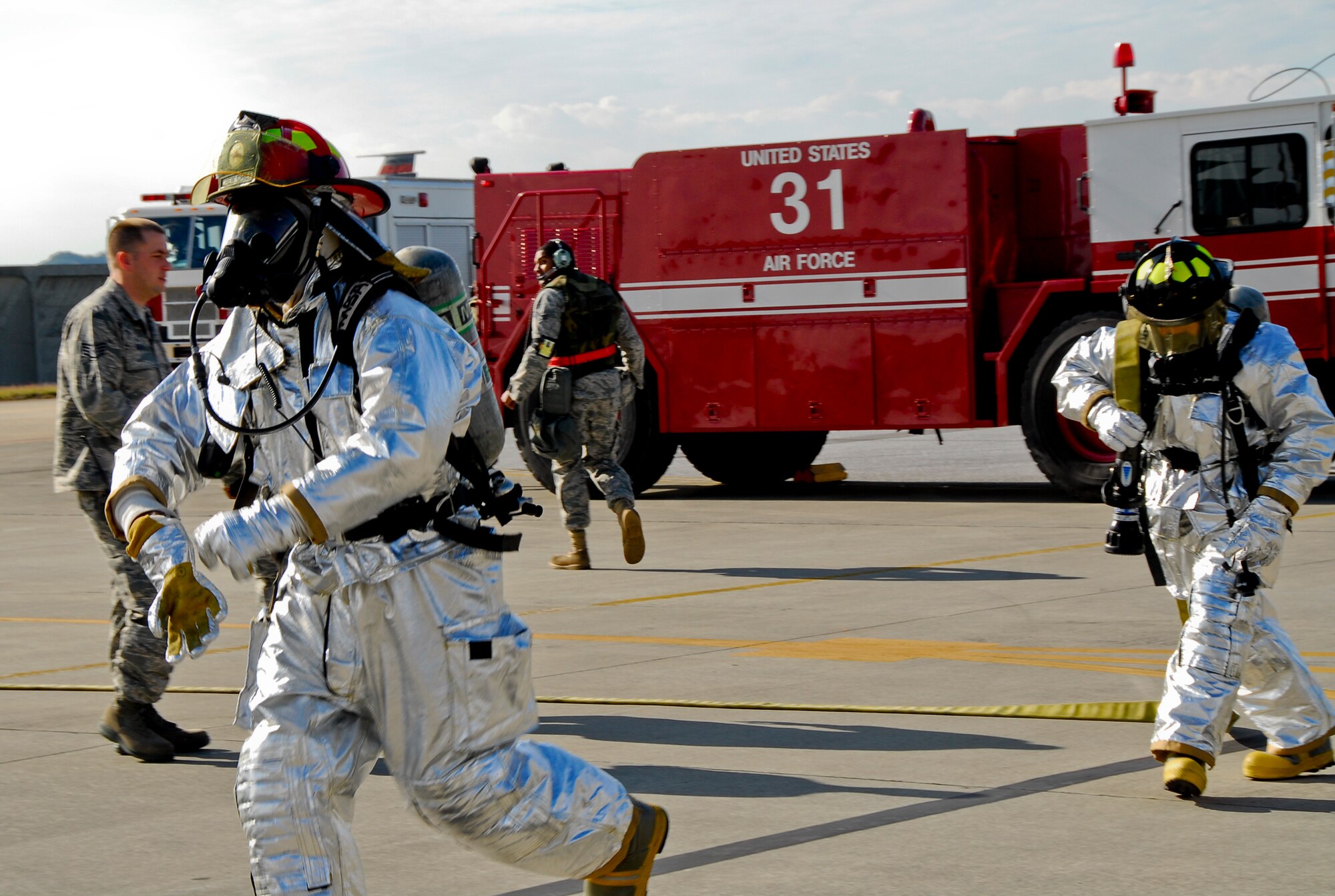 Firemen from Kadena's 18th Civil Engineer Squadron run to save simulated victims in an aircraft fire scenario during Beverly High 11-02, a local operational readiness exercise held here, Jan. 19. The exercise tested the skills and capabilities of Kadena's firemen, security forces, and flight medicine personnel, and their ability to work together during an emergency. (Air Force photo/ Airman 1st Class Maeson L. Elleman) 