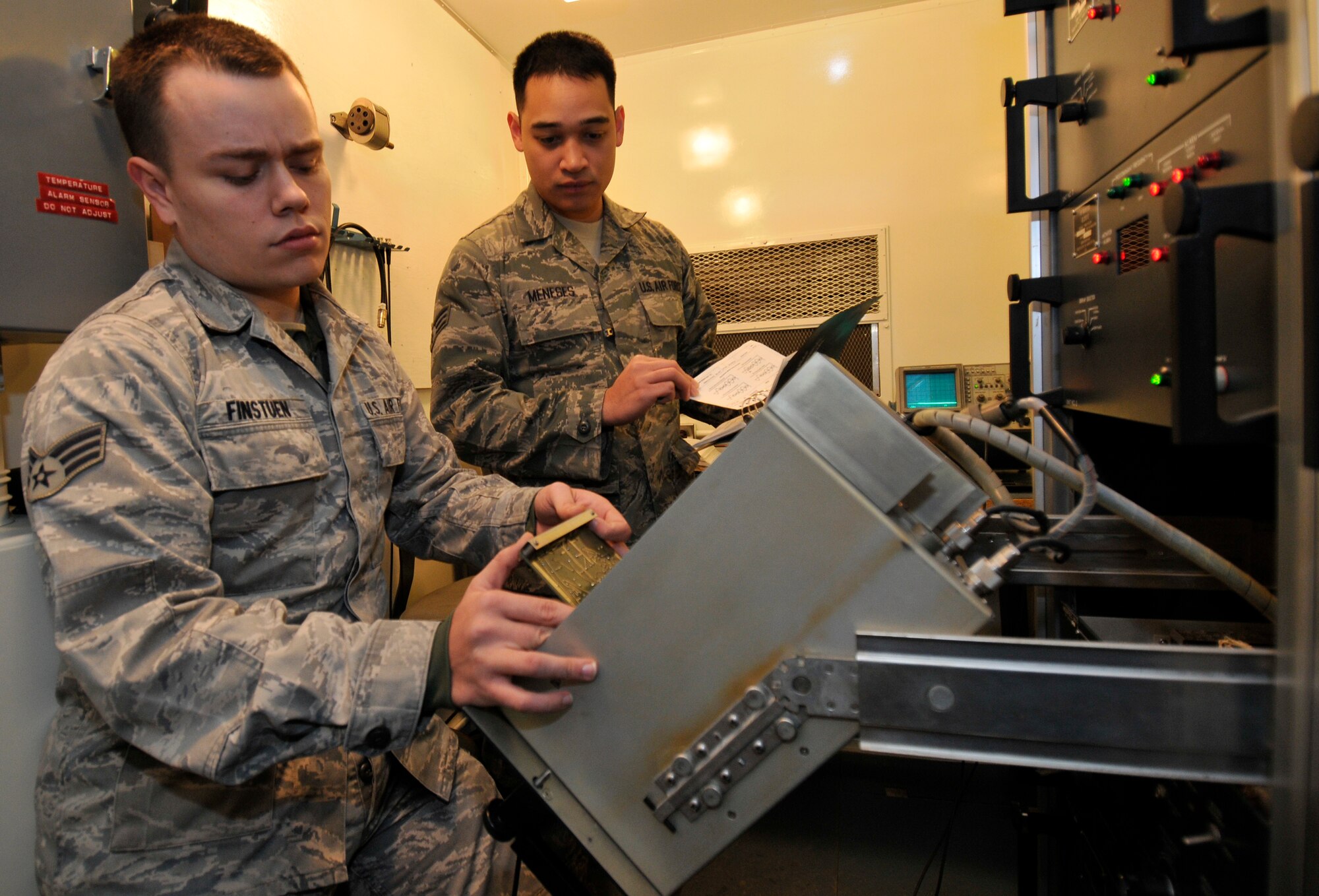 U.S. Air Force Senior Airmen Kevin Finstuen, left, and Cavin Meneses, 35th Communications Squadron airfield systems technicians, reseat a circuit board as part of an operational check-out used to clear system fault alarms on the instrument landing system Jan. 20, 2011, Misawa Air Base, Japan. The airfield uses two ILS systems, one on each end of the runway. (U.S. Air Force photo by Tech. Sgt. Phillip Butterfield/Released)

