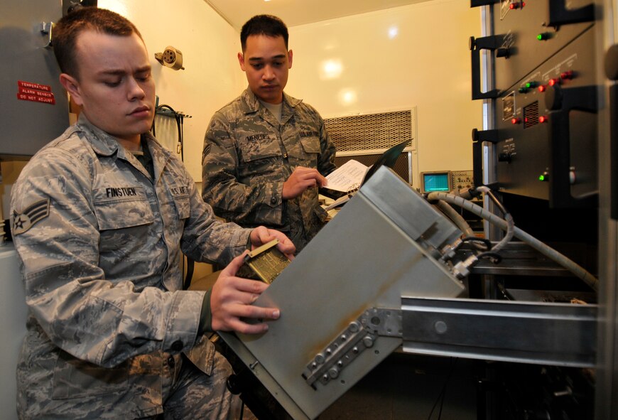 U.S. Air Force Senior Airmen Kevin Finstuen, left, and Cavin Meneses, 35th Communications Squadron airfield systems technicians, reseat a circuit board as part of an operational check-out used to clear system fault alarms on the instrument landing system Jan. 20, 2011, Misawa Air Base, Japan. The airfield uses two ILS systems, one on each end of the runway. (U.S. Air Force photo by Tech. Sgt. Phillip Butterfield/Released)

