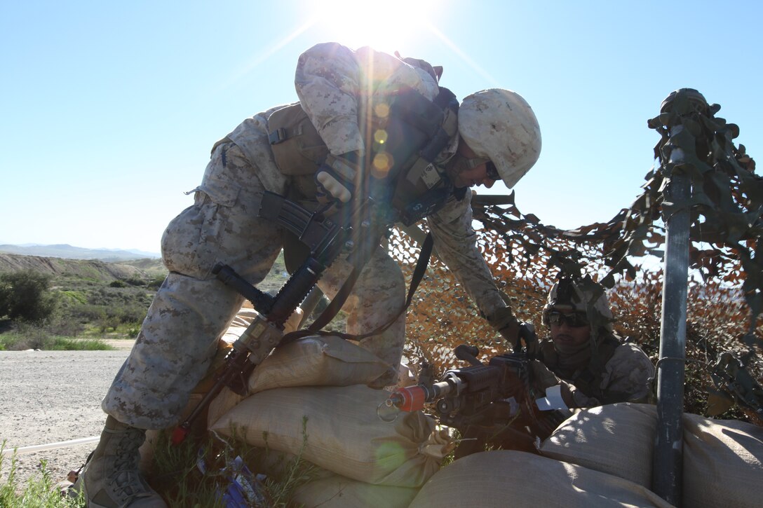 Lance Cpl. Jorge Franco helps the Marine adjust his sights on the M240B automatic machine gun during a training evolution Jan 20., at Camp Pendleton, Calif. Franco is a Mexican-American from Donna, Texas, a small city in south Texas. ::r::::n::::r::::n::::r::::n::