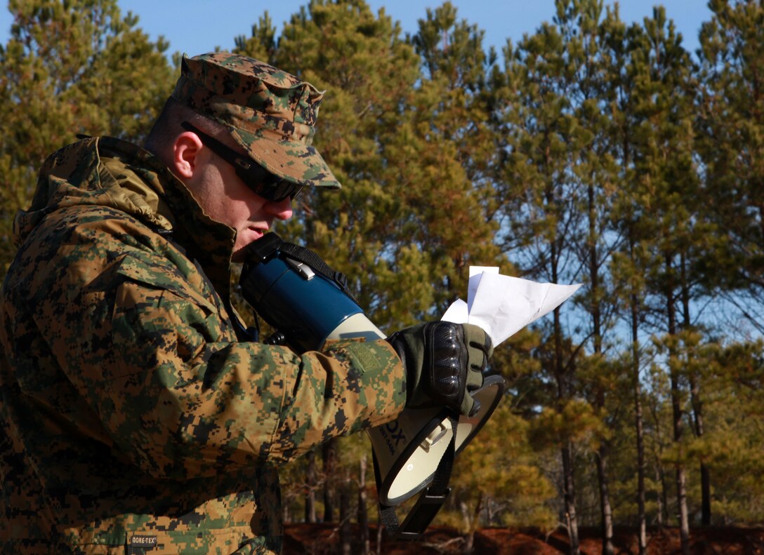 Sgt. James A. Gilliam, a combat marksmanship trainer currently with the 26th Marine Expeditionary Unit, reads commands to shooters with the 24th MEU at range K406B on Camp Lejeune, N.C. Jan. 20. The 24th MEU conducted combat marksmanship training to sustain the combat marksmanship skills of Marines and Sailors within the Command Element.