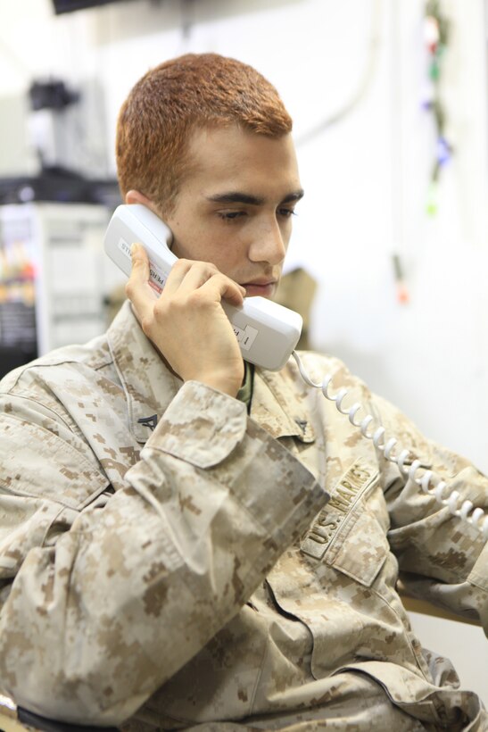 USS KEARSARGE at sea -- Lance Cpl. Brandon Walker, a mortarman with Weapons Company, Battalion Landing Team 3/8, 26th Marine Expeditionary Unit, talks to his wife, Jana, after the birth of his second child Shylee, Jan. 21, 2011. Walker was able to hear Shylee cry for the first time over the phone. This was the second child birth Walker has missed due to deployment.