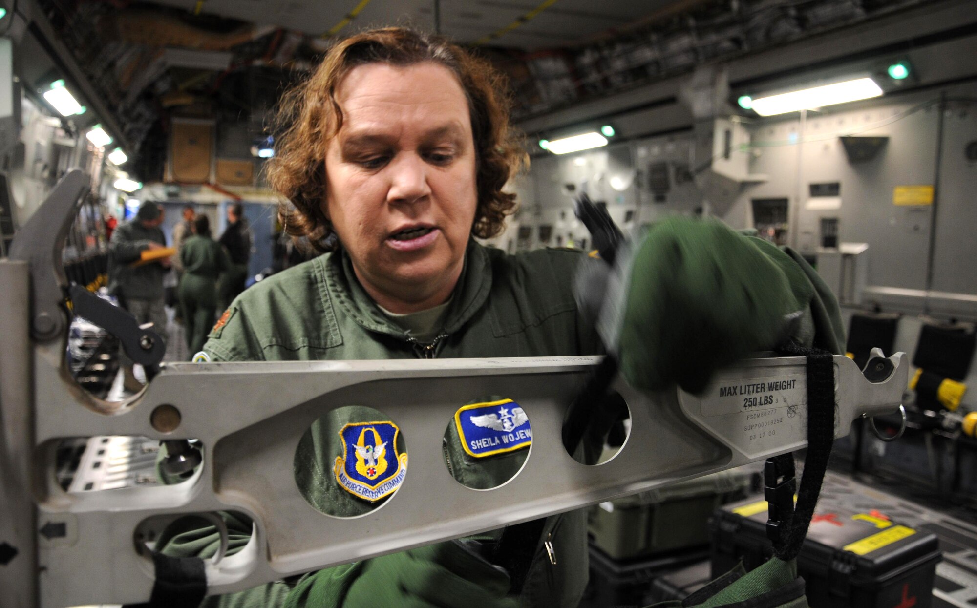 MCCHORD FIELD, Wash.- Maj. Sheila Wojewodzki, 446th Aeromedical Evacuation Squadron flight nurse, sets up a patient roll pack on a stanchion arm in a C-17 Globemaster III in preparation for a training mission to Joint Base Pearl Harbor-Hickam, Hawaii, Jan. 10. The 446th AES Reservists keep their skills sharp by participating in missions like these. (U.S. Air Force photo/Master Sgt. Jake Chappelle) 