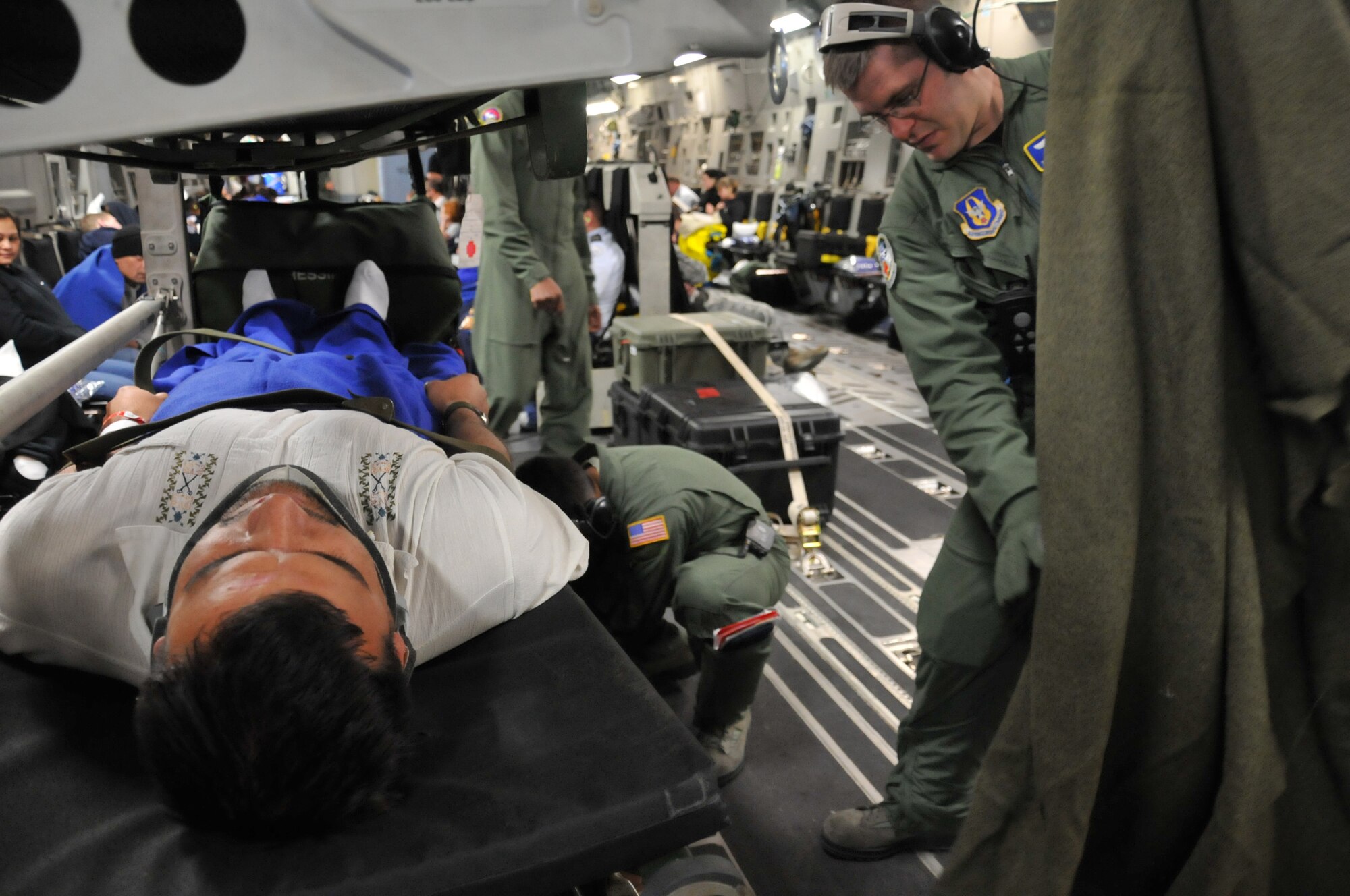 JOINT BASE PEARL HARBOR-HICKAM, Hawaii- Staff Sgt. Daniel Nelson, a medical technician with the 446th Aeromedical Evacuation Squadron, McChord Field Wash., prepares a blanket to provide comfort for Capt. Lee Wilkerson, a KC-135 Stratotanker pilot from Spokane, Wash., who injured his neck in Hawaii, Jan 11. The 446th AES team was on a training mission and Captain Wilkerson helped them use some of their skills for in-flight patient care. (U.S. Air Force photo/Master Sgt. Jake Chappelle) 