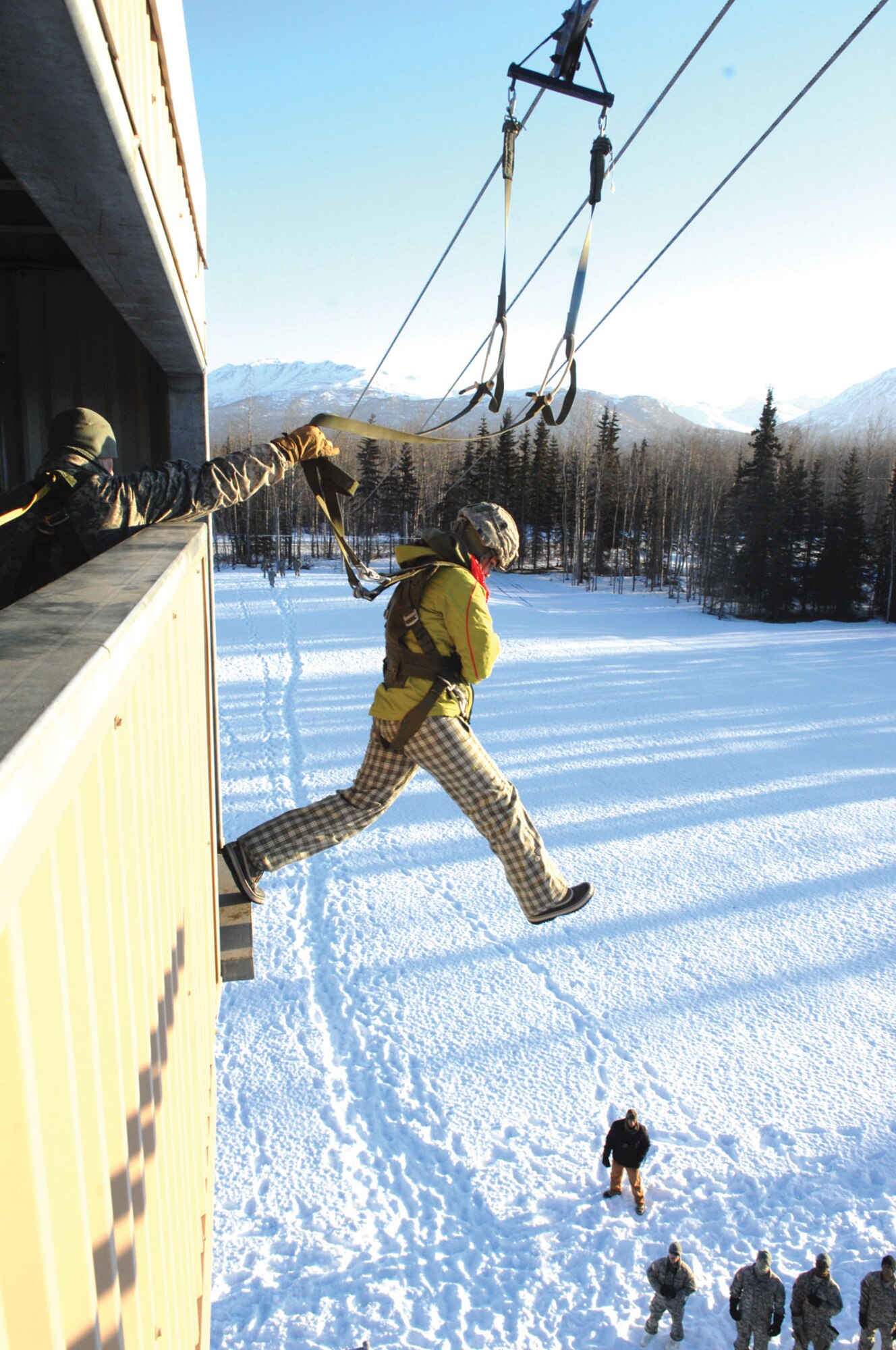 Army Staff Sgt. Kyle Romohr, left, keeps the risers away from the head and neck of a guest jumper at U.S. Army Alaska’s ‘jump tower” during G.I. Jane Day, Jan. 14. As part of the day of Army training for spouses, wives learned some of what their husbands experience during training. See more photos of G.I. Jane Day on page A-3.(U.S. Army photo by Army Staff Sgt. Matthew E. Winstead/4-25th ABCT PAO)