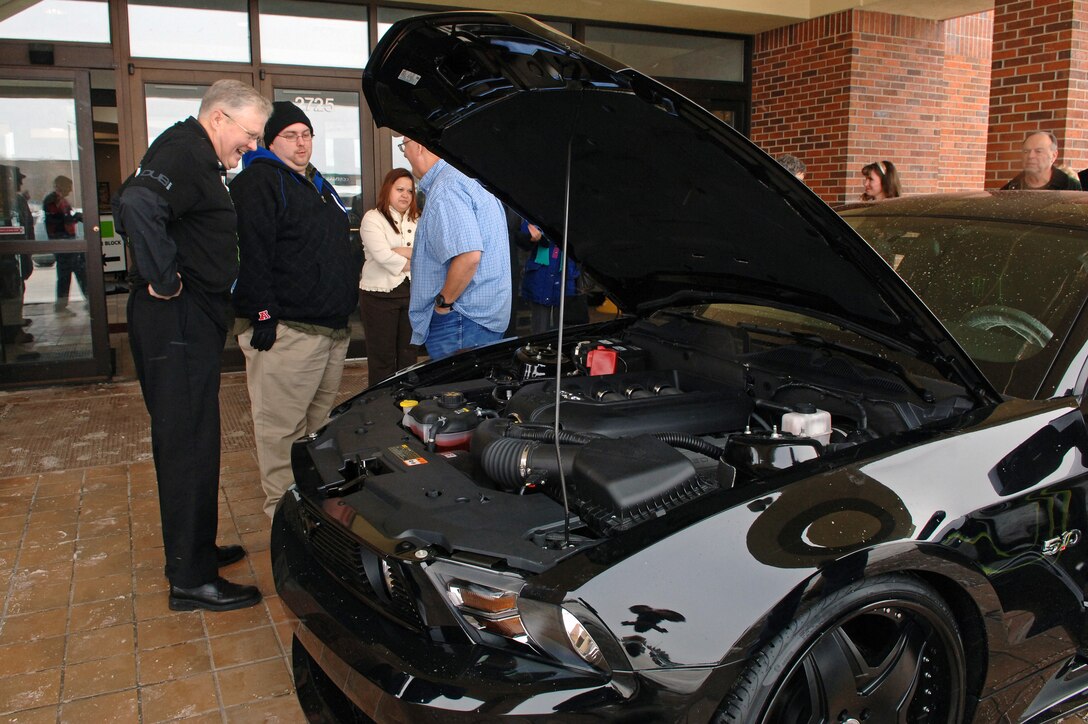 Retired Air Force Lt. Col. Larry Converse inspects the engine of his new Ford Mustang at the Ellsworth Air Force Base, S.D. base exchange, Jan. 20, 2011. Mr. Converse won the car after he entered in to a worldwide contest sponsored by the Army and Air Force Exchange Service and the Monster Beverage Company. (U.S. Air Force photo/Senior Airman Jarad A. Denton)
