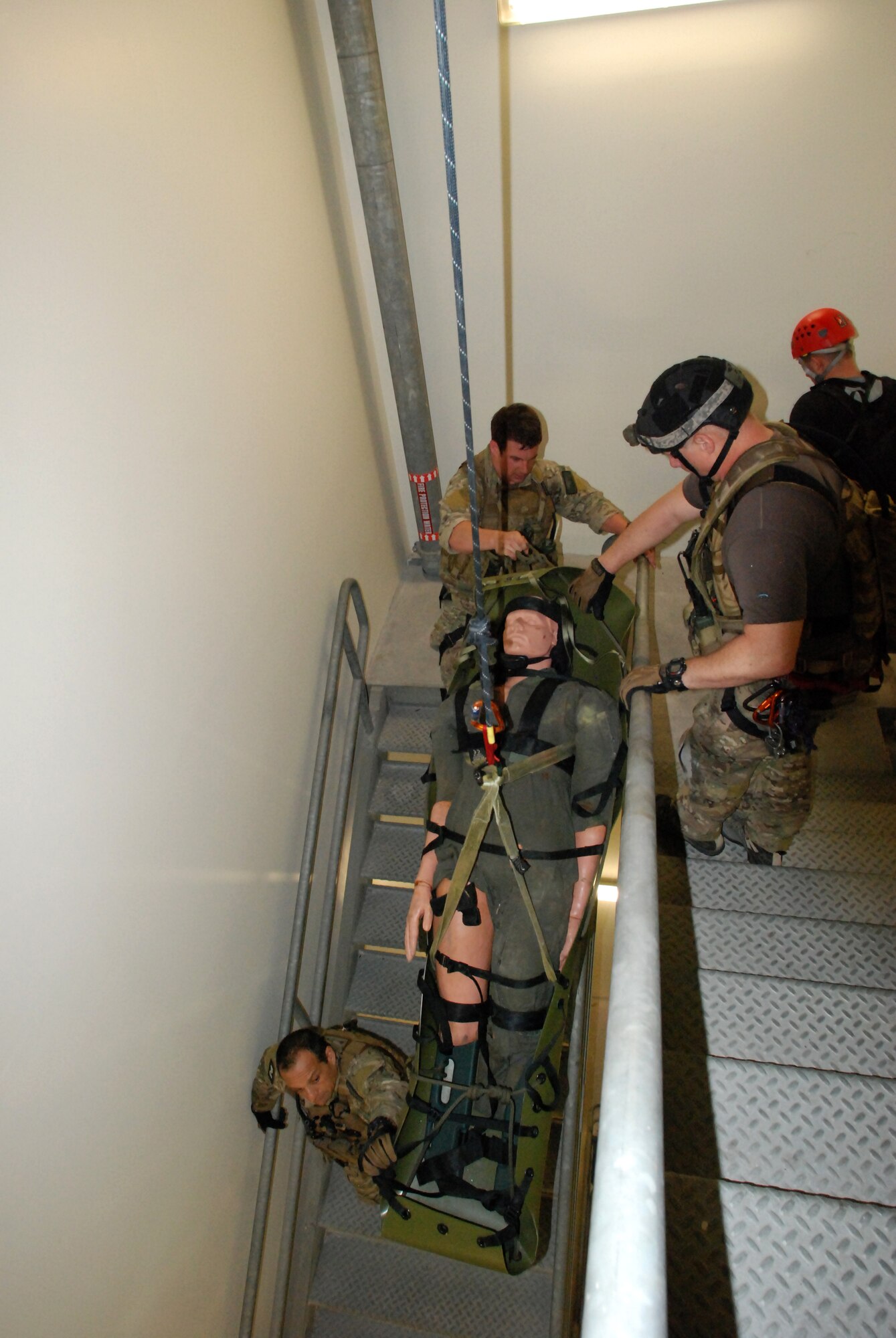 CAPE CANAVERAL AIR FORCE STATION, Fla. - Master Sgt. Ken Surry, Capt. James Sluder and Master Sgt. Robert Smith, U.S. Air Force Reserve pararescuemen from the 920th Rescue Wing, Cocoa Beach, Fla., practice their rescue skills in a narrow stairwell at an empty Titan rocket complex here. The training, by ROCO Rescue, is high-angle, high-altitude and confined space rescue refresher for the PJs and combat rescue officers.   (U.S. Air Force photo/Staff Sgt. Leslie Kraushaar)