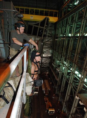 CAPE CANAVERAL AIR FORCE STATION, Fla. - Master Sgt. Chris Seinkner, reserve pararescueman from the 920th Rescue Wing, Cocoa Beach, Fla., and ROCO instructor Josh Hill, pull Oscar, the "victim," to safety at the top of the empty Titan rocket assembly complex here Jan 20th. The training, by ROCO Rescue, is high-angle, high-altitude and confined space rescue refresher for the PJs and combat rescue officers.  (U.S. Air Force photo/Staff Sgt. Leslie Kraushaar)