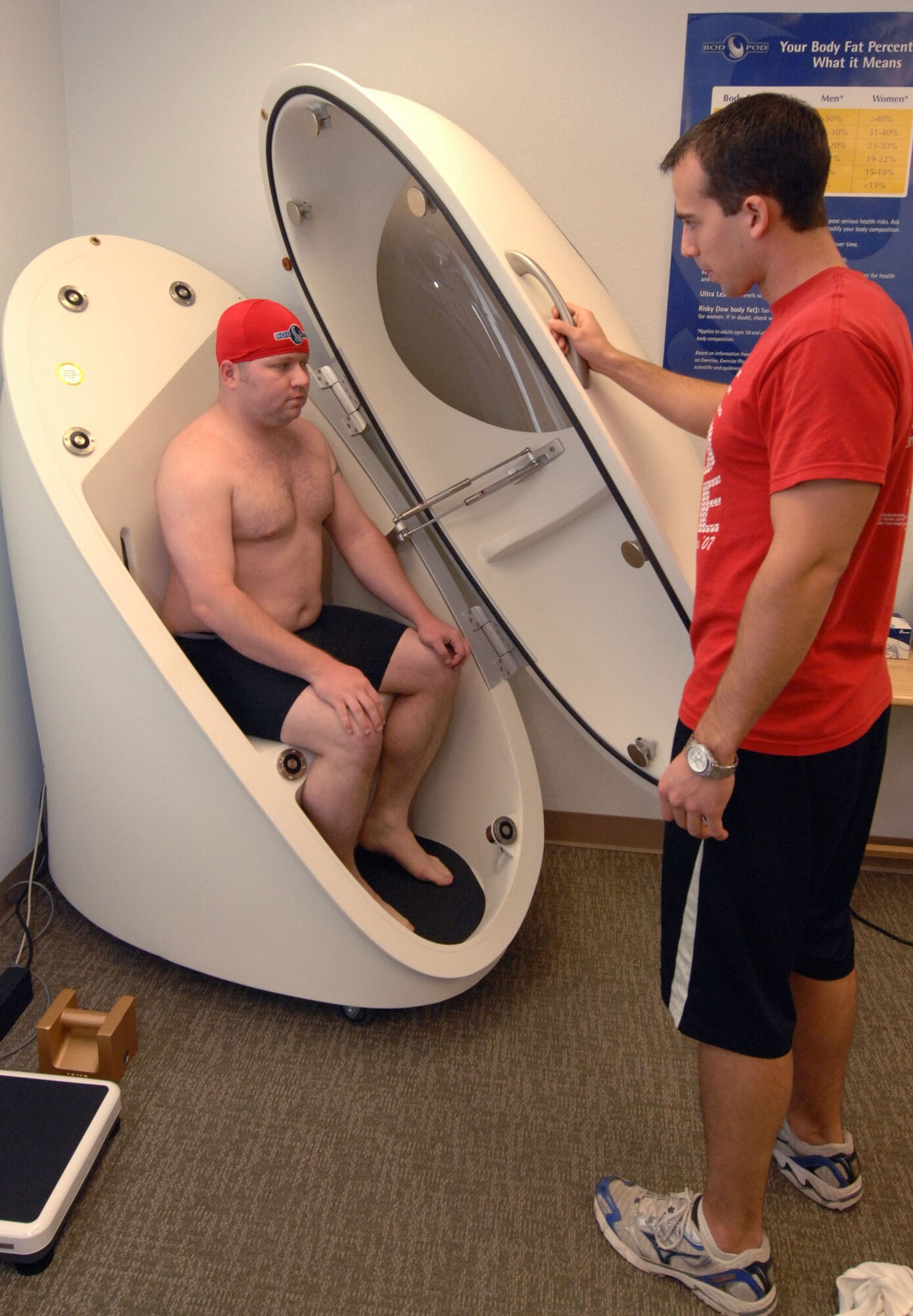 DAVIS-MONTHAN AIR FORCE BASE, Ariz. - David Friederich (right), Health and Wellness Center health and fitness specialist, gives final instructions to Senior Airman Shane Dunaway (left), 355th Fighter Wing public affairs journeyman, before closing the door on the BOD POD at the HAWC here Jan. 10. The BOD POD is a machine that measures air displacement and uses the results to calculate body fat percentage and measure resting metabolic rate. (U.S. Air Force photo/Airman 1st Class Mike Washburn)