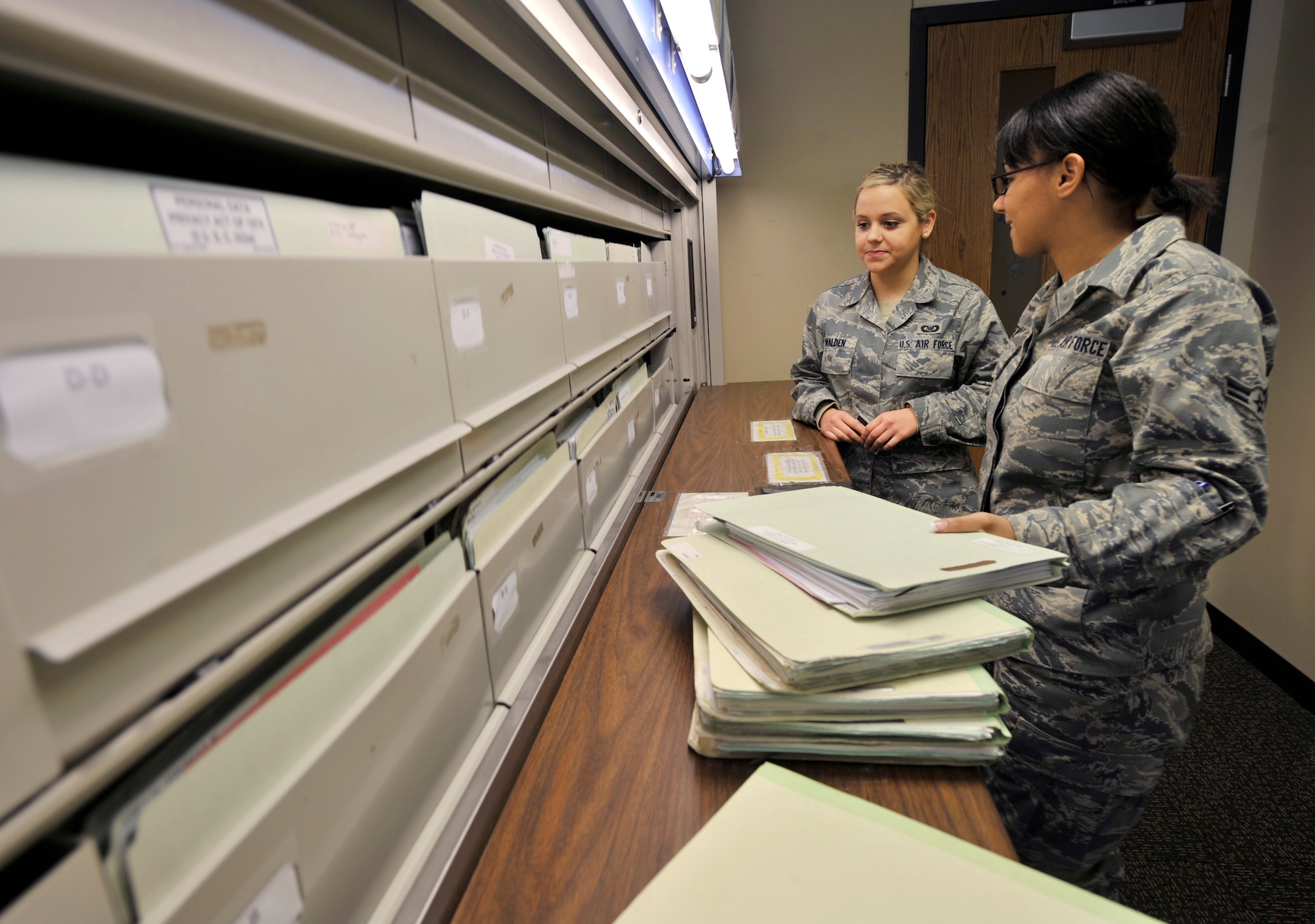 Airman 1st Class Jamie Walden (left) and Airman 1st Class Nicole Cofey, aviation resource managers with the 2nd Operations Support Squadron, sort through files of aircrew members in the Host Aviation Resource Management office on Barksdale Air Force Base, La., Jan. 19. The HARM office makes sure all aircrew are physically qualified, keeps track of all flight record folders, logs flight times, awards ratings and badges, gives flight record reviews, publishes aeronautical orders and in/out processes all flyers and jumpers on base. (U.S. Air Force photo/Senior Airman Chad Warren)(RELEASED)