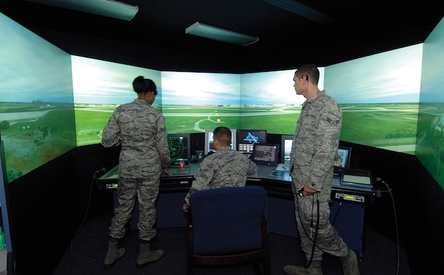 Located at the foot of the Air Traffic Control Tower, the training simulator is a 360-degree Tinker virtual tower. Lead by instructors through customized events, the trainees learn Tinker-specific language, aircraft and scenarios that acclimate the Airmen to the real world high above. Training, in the tower and in the simulator, may take up to a year before the Airman is rated. (Air Force photos by Margo Wright)