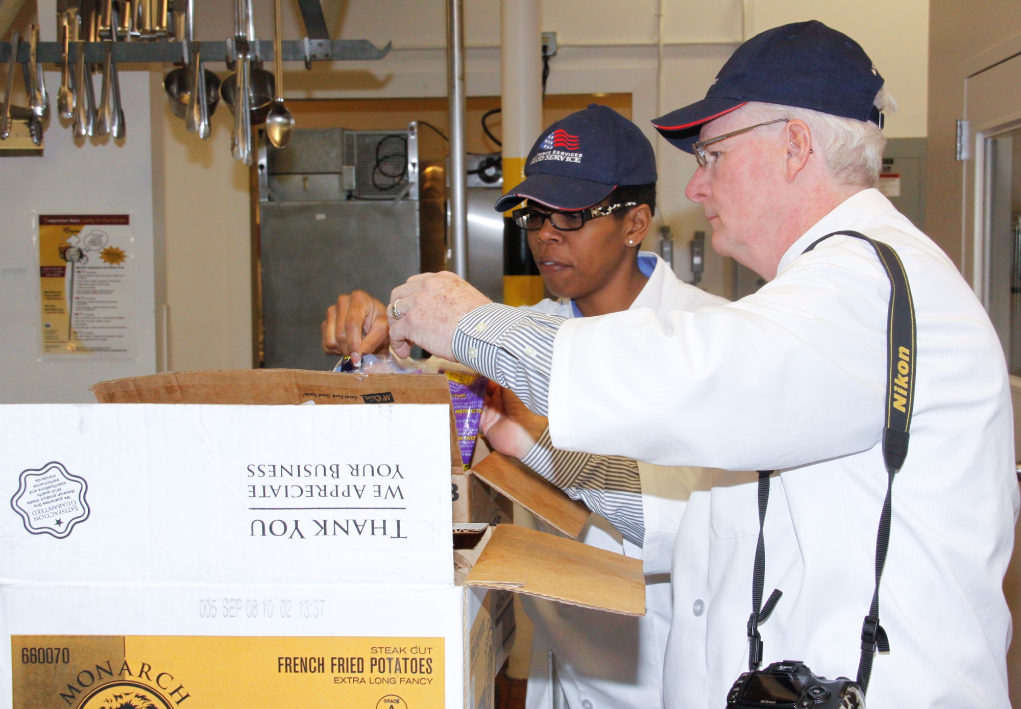 Retired Master Sgt. Renee Houey, left, from Headquarters Air Force Reserve Command Plans and Requirements, and Mr. Dick Crawford, vice president of the Hennessy Travelers Association, inspect the code dates for French fries in the Dining Hall kitchen. The inspectors were part of a three-member team that evaluated the Dining Hall for the John L. Hennessy Awards Program. The Hennessy Award is the oldest military food service award. (Photo by Tech. Sgt. Scott Pryor)