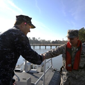 Navy Chief Warrant Officer 3 John WIlson welcomes Brig. Gen. William Bender, commander, United States Air Force Expeditionary Center, onboard a patrol boat at Joint Base Charleston - Weapons Station, Jan. 20. General Bender visited JB CHS for the first time after the realignment of the 628th Air Base Wing under the U.S. Air Force Expeditionary Center.