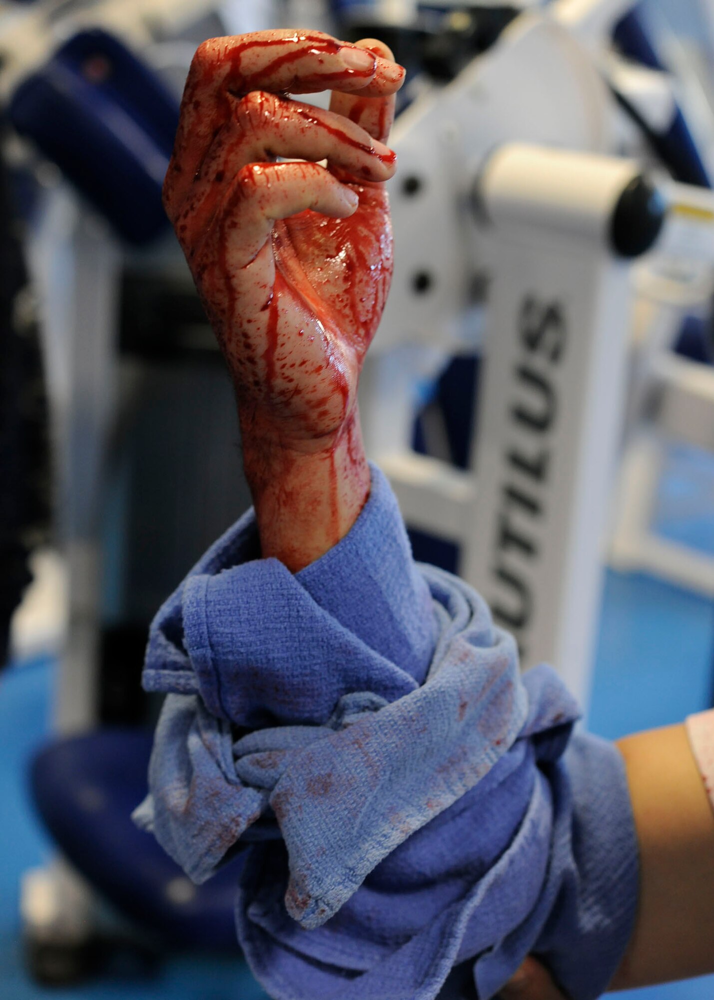 ROYAL AIR FORCE LAKENHEATH, England - Capt. Chris Bulla, 48th Operational Support Squadron weapon systems officers, elevates wounded arm during a wing level exercise at the Lakenheath Sports & Fitness Center on Jan. 21. This exercise tested the base populace-s reaction time to an active shooter incident. (U.S. Air Force photo/Senior Airman Tiffany M. Deuel)