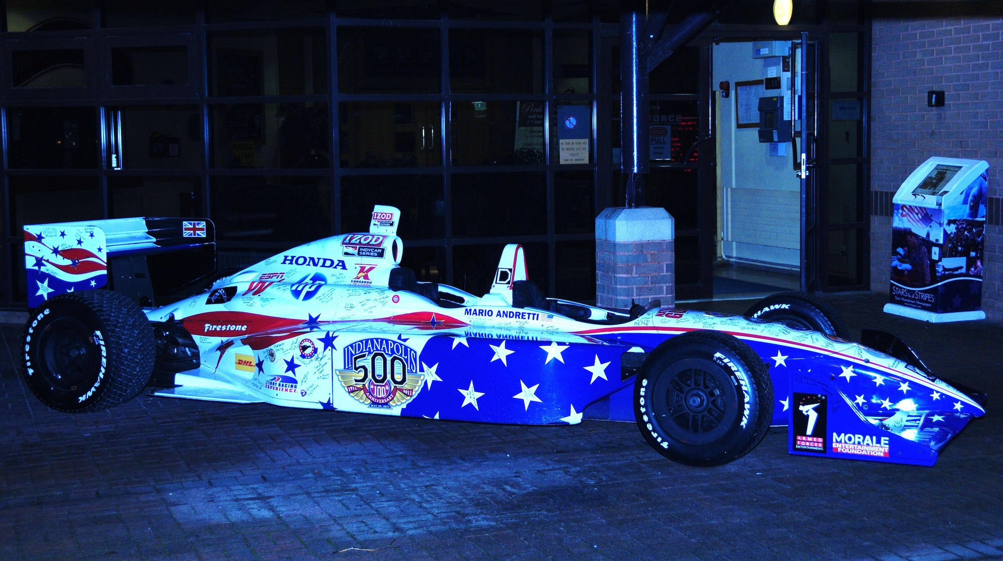 ROYAL AIR FORCE LAKENHEATH, England -- Mario Andretti's Indy 500 Centennial Tour racecar sits in front of the Liberty Club during the meet and greet time with fans, where racing legends such as Davey Hamilton, Johnny Rutherford, Al Unser Jr., Sarah Fisher and others shared stories about their lives in the fast lane and showed appreciation to military members and their families. The tour was presented by Armed Forces Entertainment.  (U.S. Air Force photo/Staff Sgt. Connor Estes)
