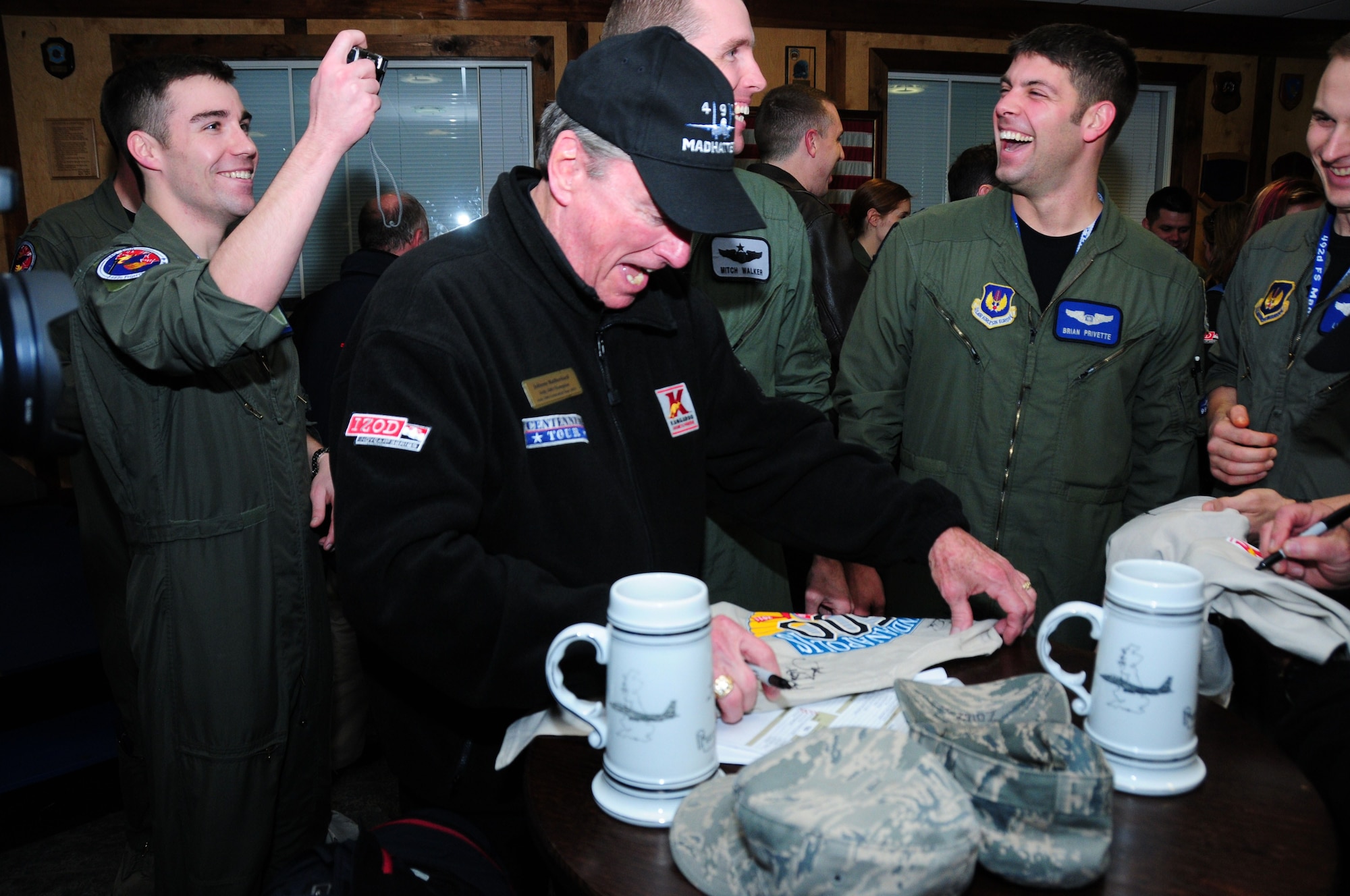 ROYAL AIR FORCE LAKENHEATH, England -- Racing IndyCar champion Johnny Rutherford signs autographs at the 492nd Fighter Squadron's heritage room during a tour of the Strike Eagle Complex, Jan. 20. The Indy 500 Centennial Tour, which was sponsored by Armed Forces Entertainment, visited overseas military bases throughout Europe and Southwest Asia to show appreciation to servicemembers and their families. (U.S. Air Force photo/Staff Sgt. Connor Estes)
